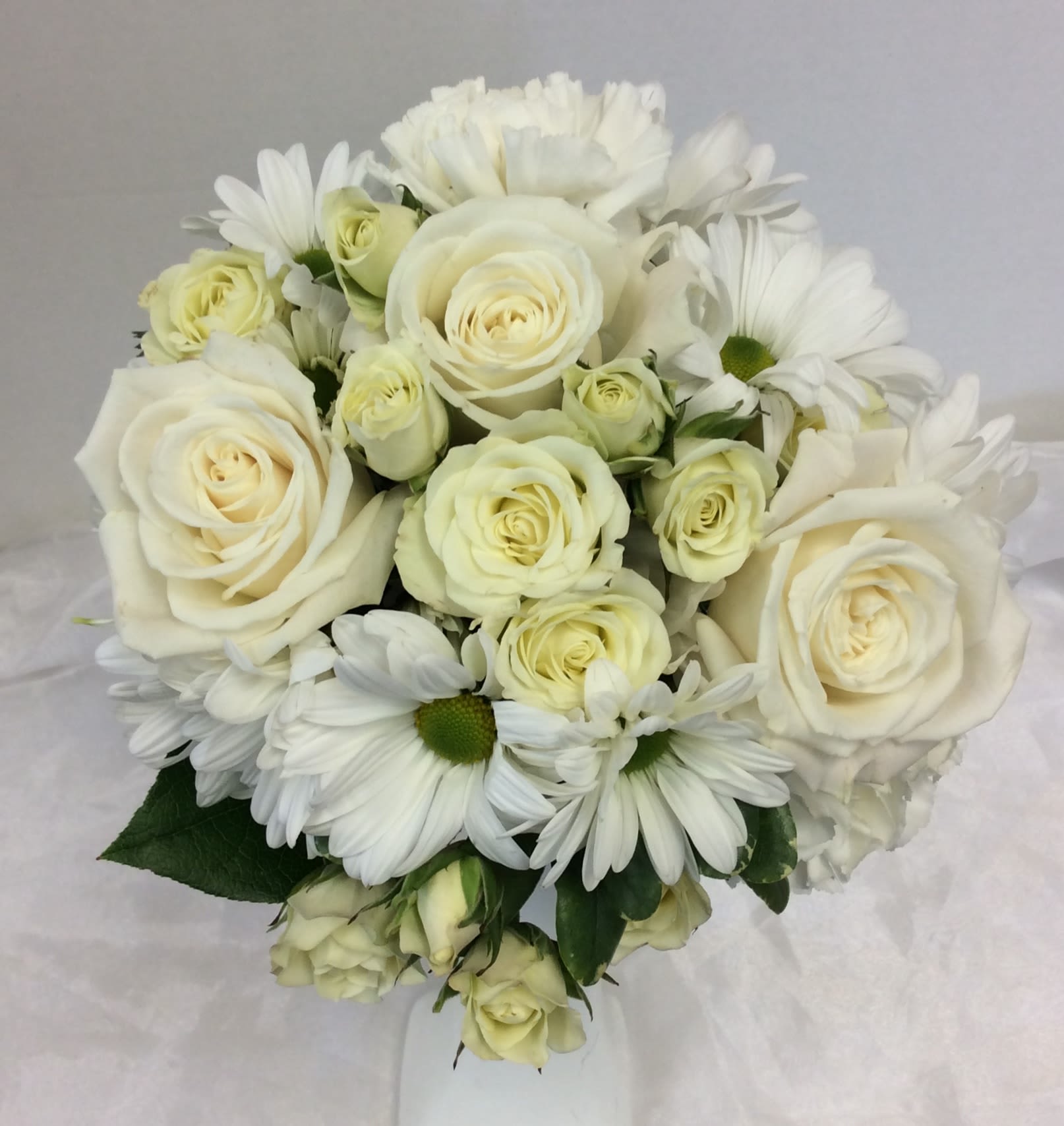 White roses and daisies arranged in a bouquet