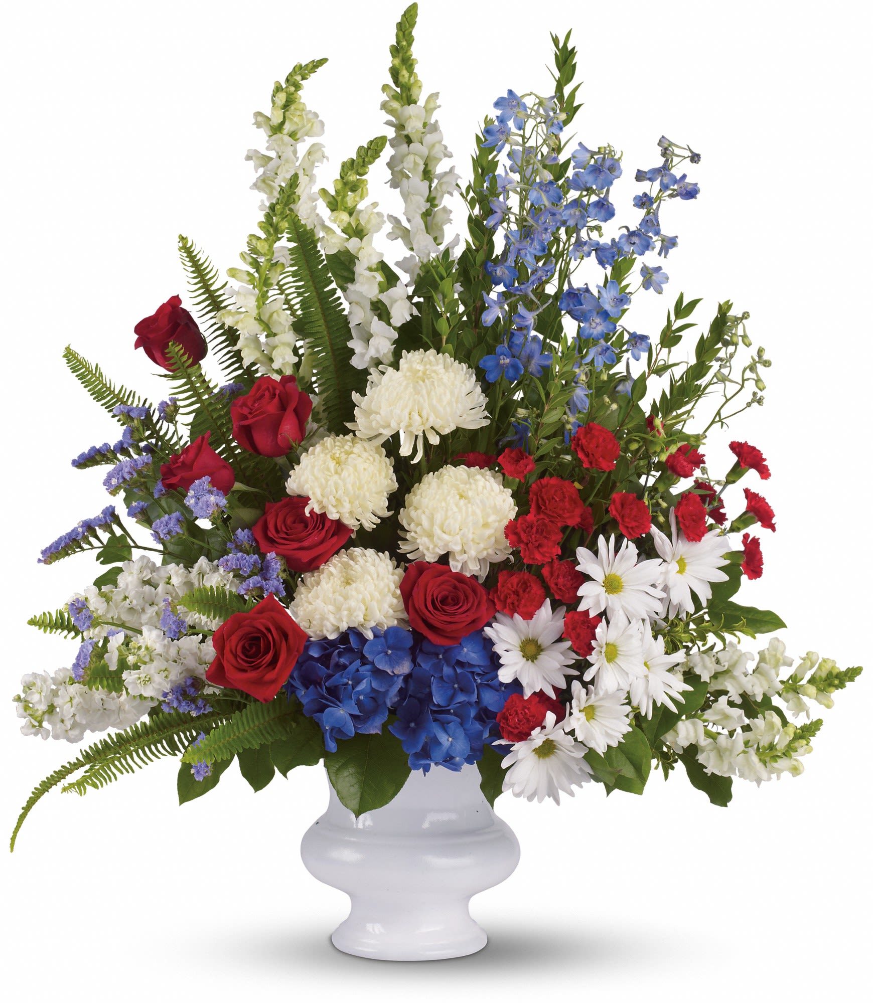 Large red, white, and blue floral arrangement in a white vase