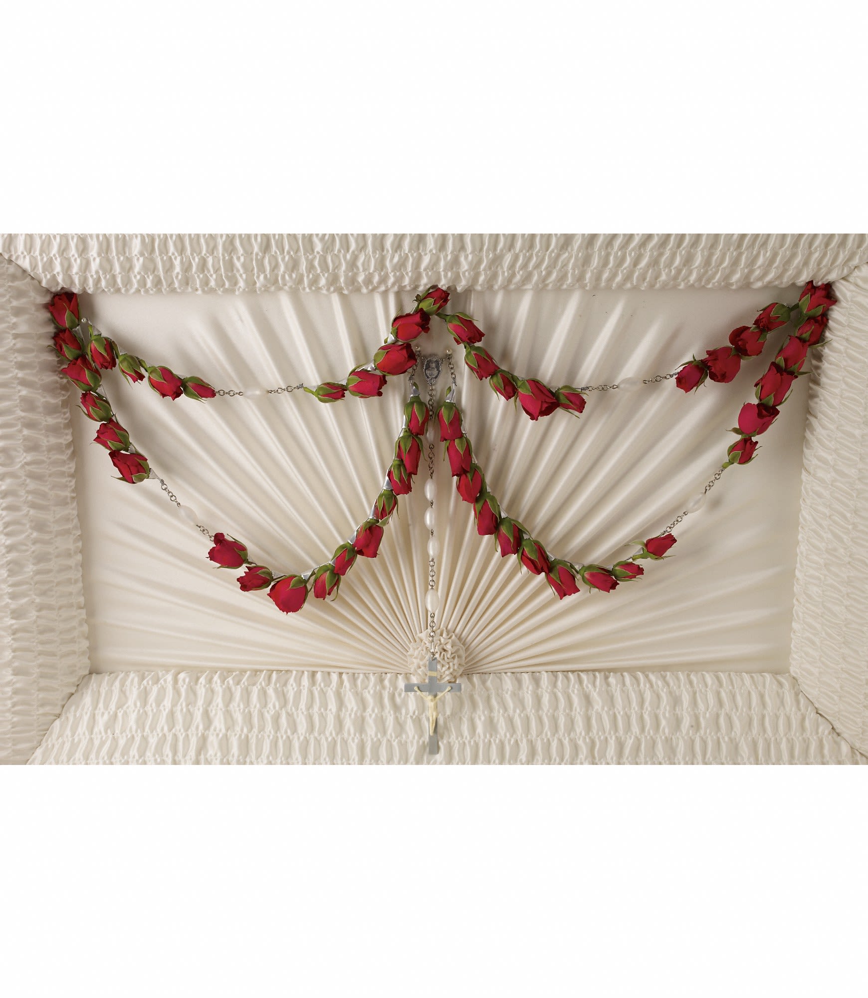 White casket with red rose garlands and a cross pendant