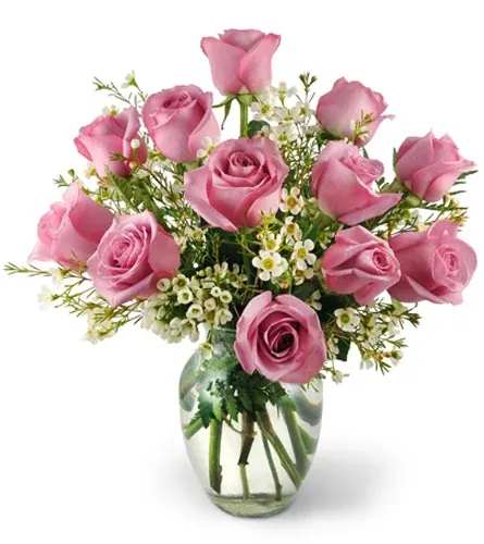 Pink roses arranged in a clear glass vase with small white filler flowers