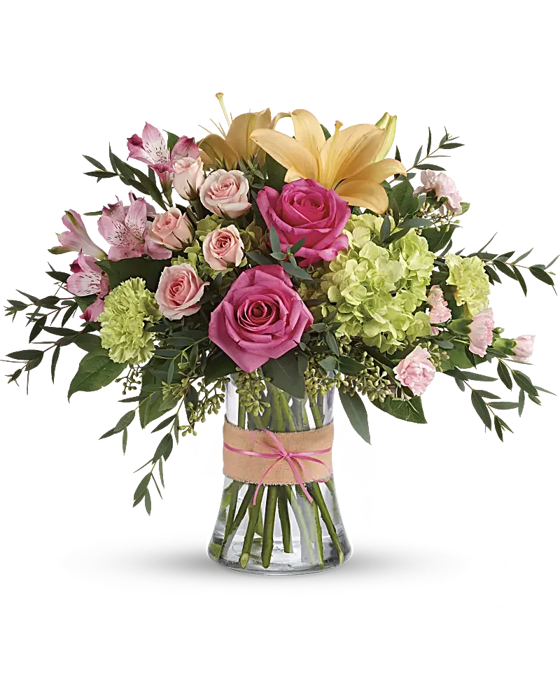 Bouquet of pink roses, lilies, and green hydrangeas in a glass vase