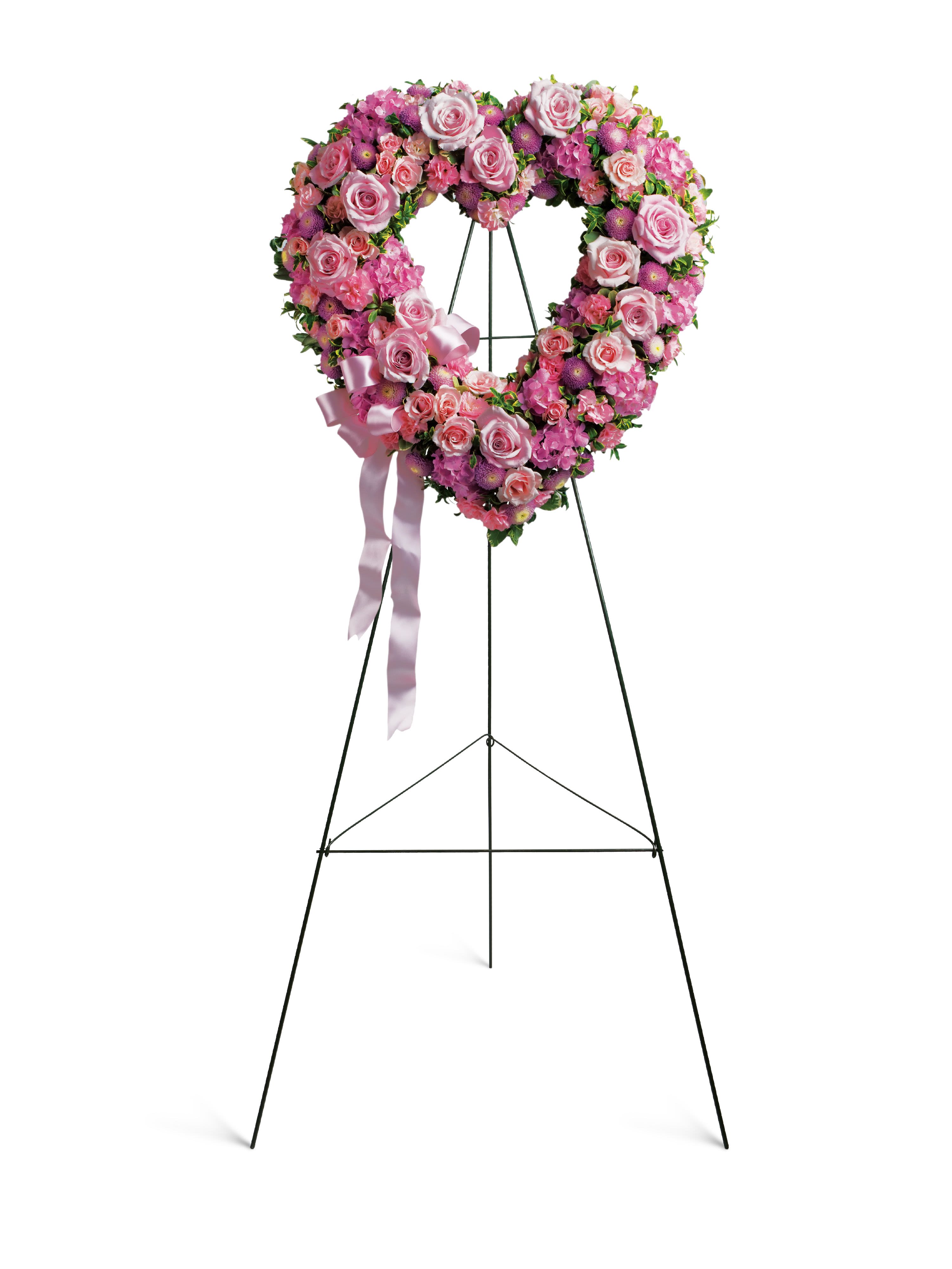 Heart-shaped pink floral wreath on a standing easel with ribbon