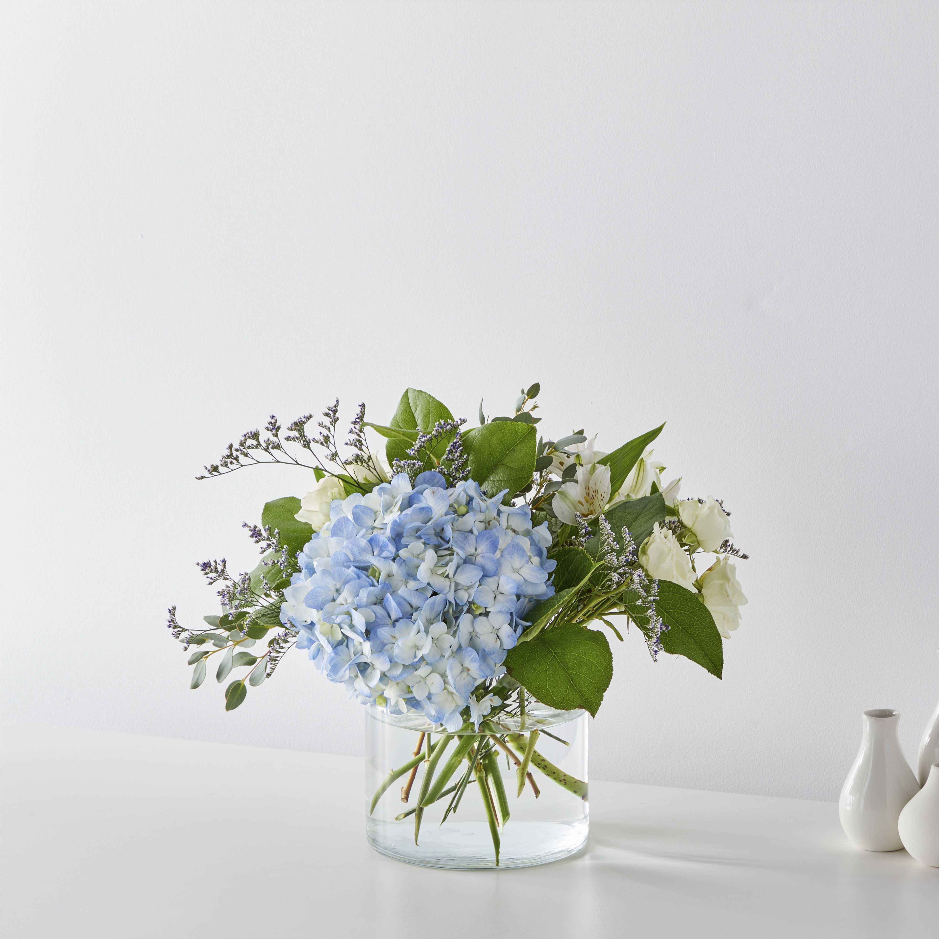 Coastal Blossom - Open the shutters to the ocean breeze through the blue hydrangea, delphinium, and ivory roses.
