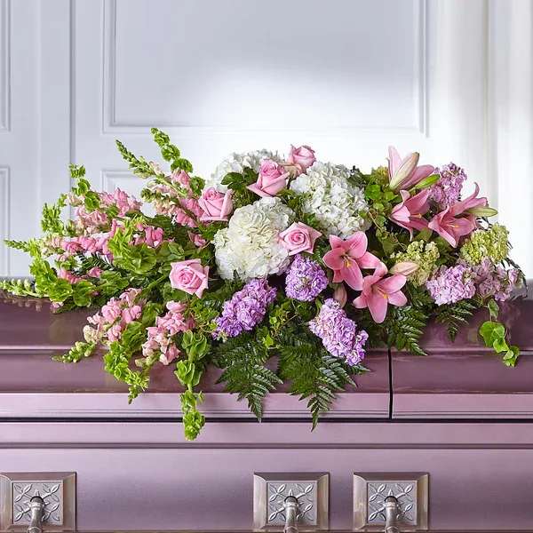 Pink and white floral casket spray with lilies and roses
