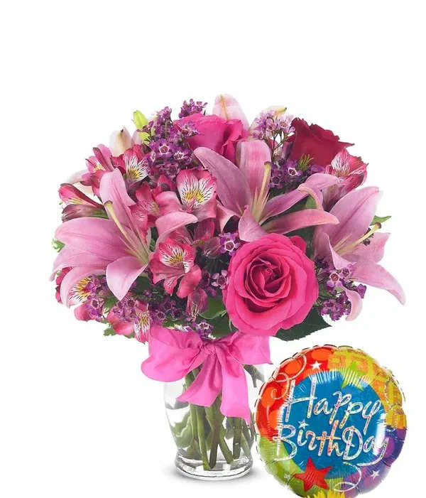 Pink mixed bouquet in a glass vase with a birthday balloon