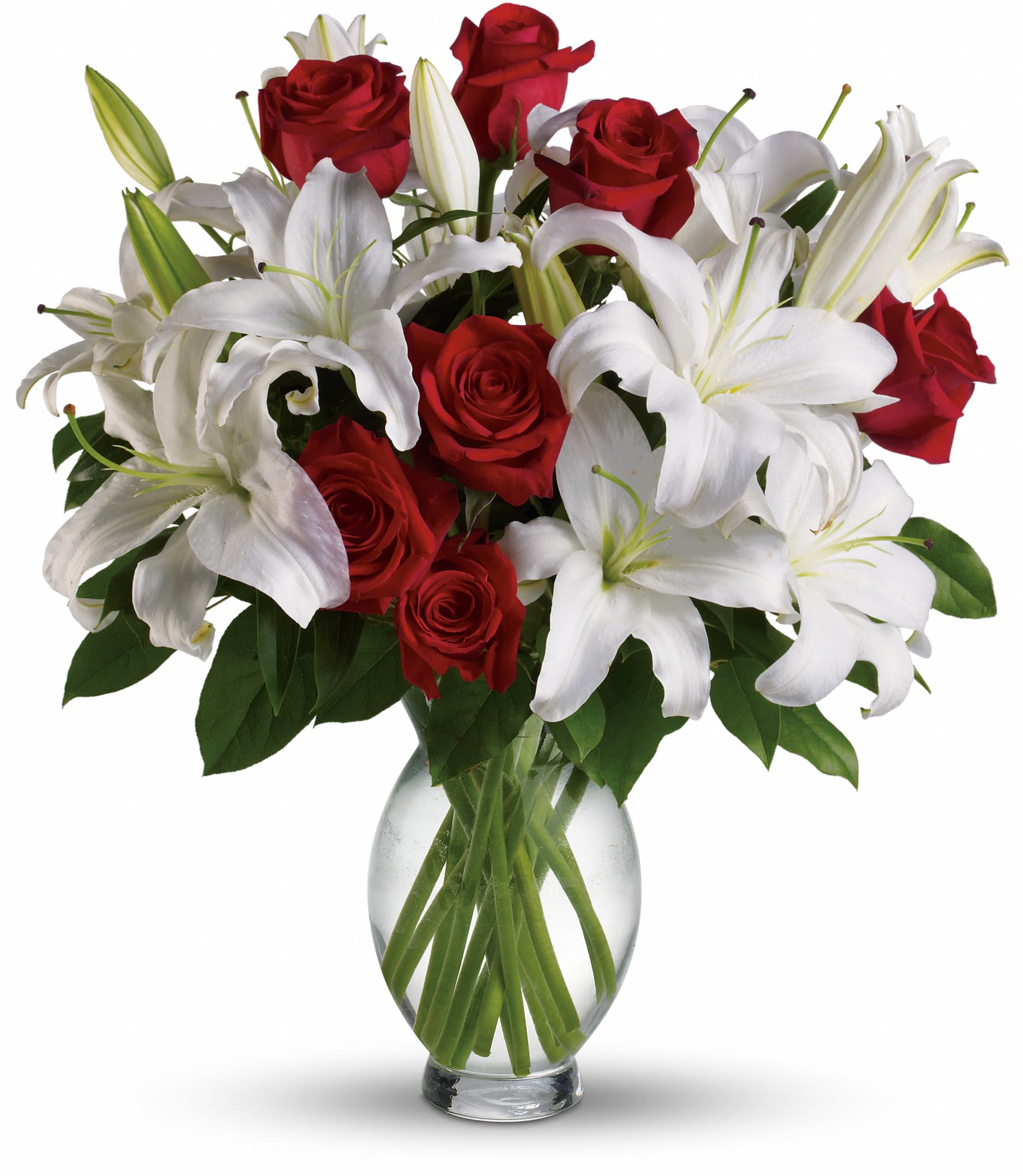 Red roses and white lilies arranged in a clear glass vase