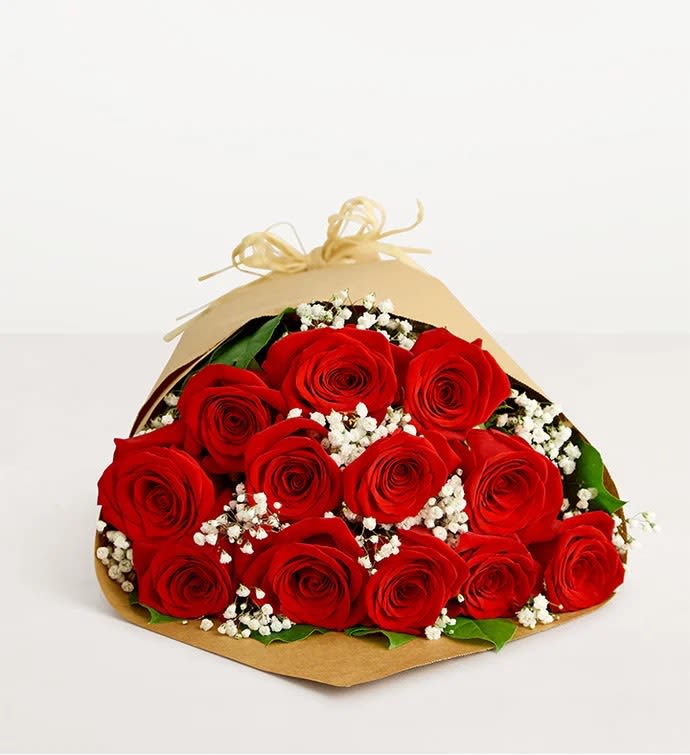 Bouquet of red roses with white baby's breath in brown paper wrap