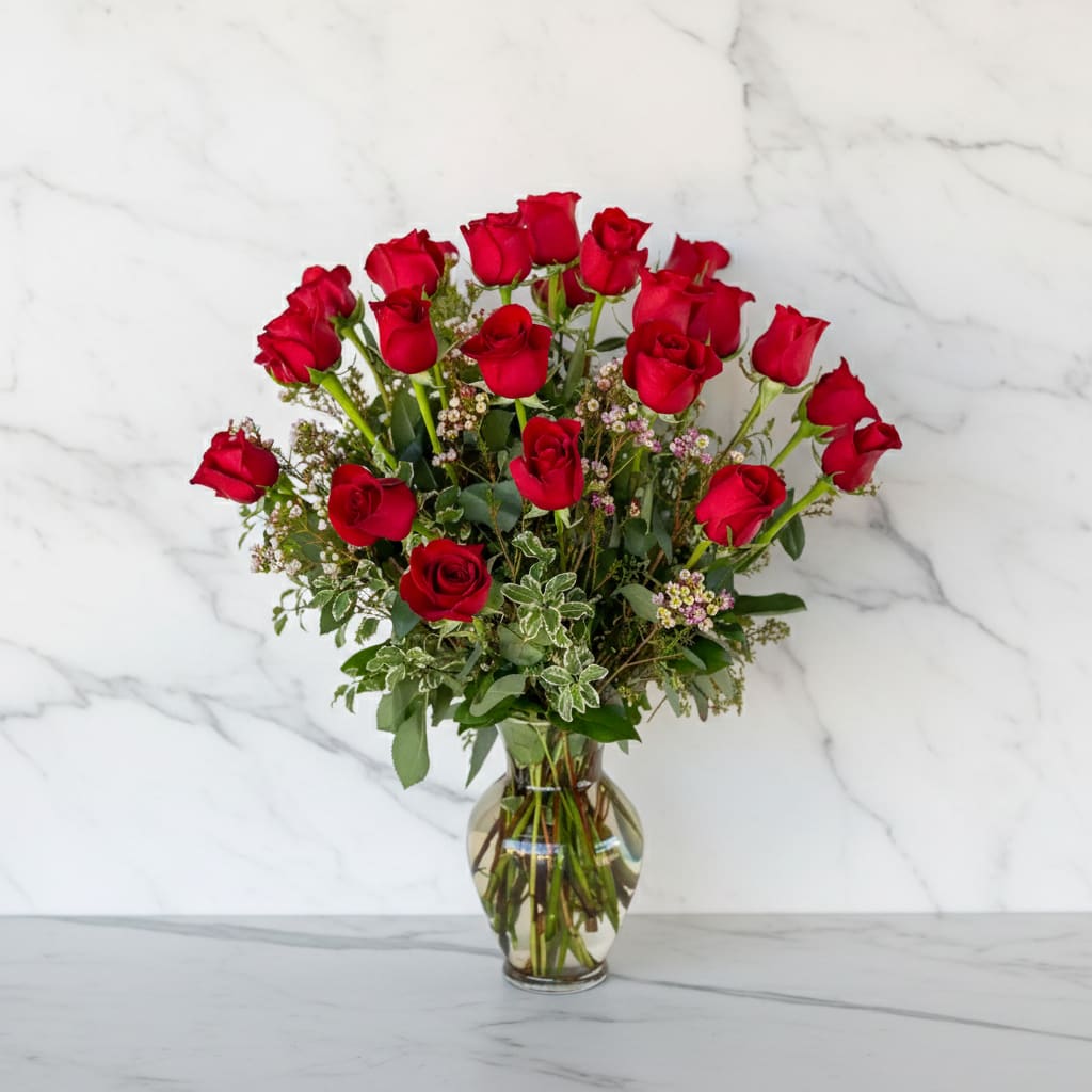 Red roses arranged in a clear glass vase