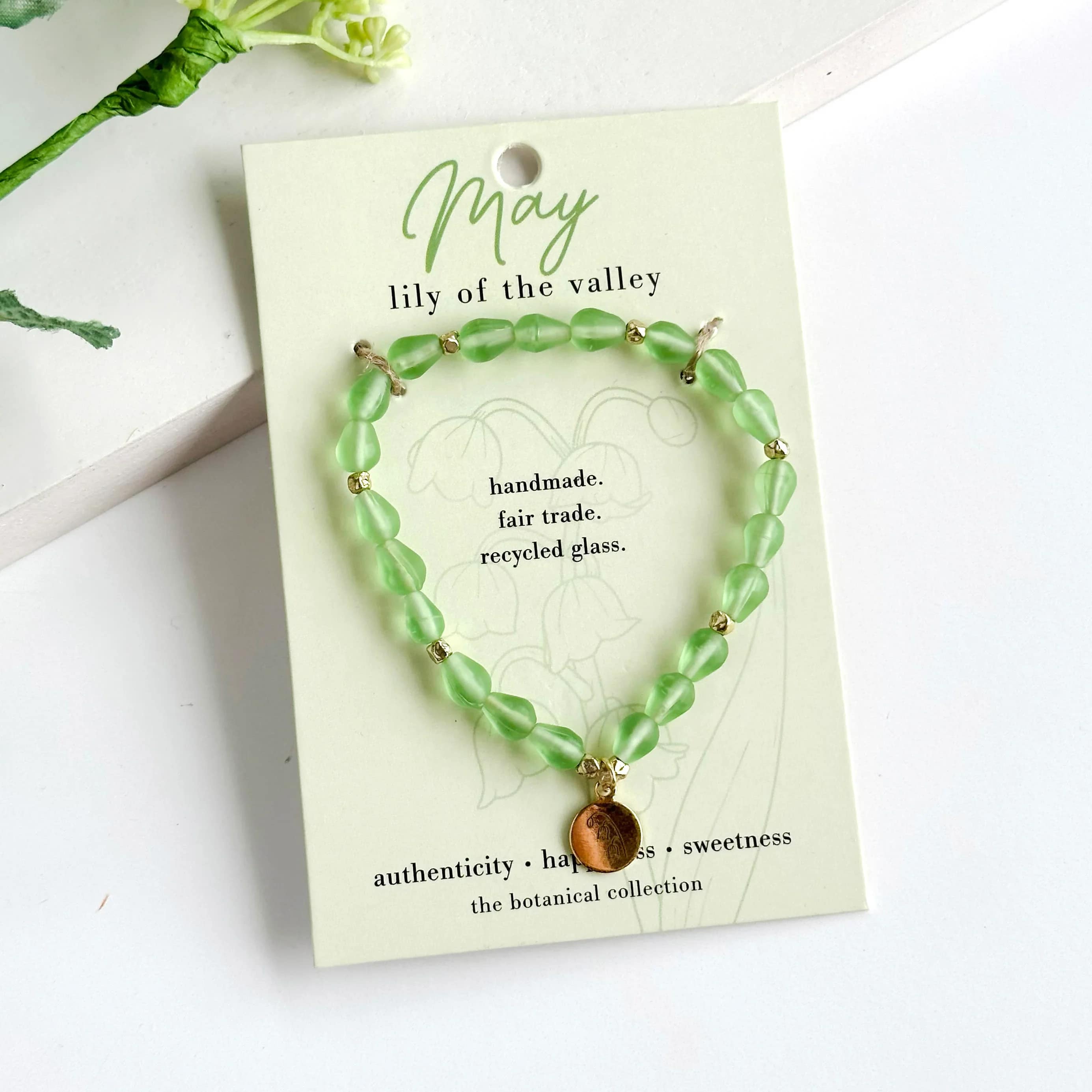 May-Birth Flower Bracelet - Hello, May!  Part of our Botanical Collection, the May Bracelet is crafted from bright green glass beads, brass accent beads, and features a lily of the valley charm. Great for gifting, the card features the lily of the valley and it's symbols of authenticity, happiness and sweetness, along with a garden-inspired quote. This bracelet also benefits an urban community garden project!  The semi-opaque beads have a satin, frosted texture and are handmade from recycled glass. The flower charm is 24k gold plated.   Sustainably handmade by women artisans in India.