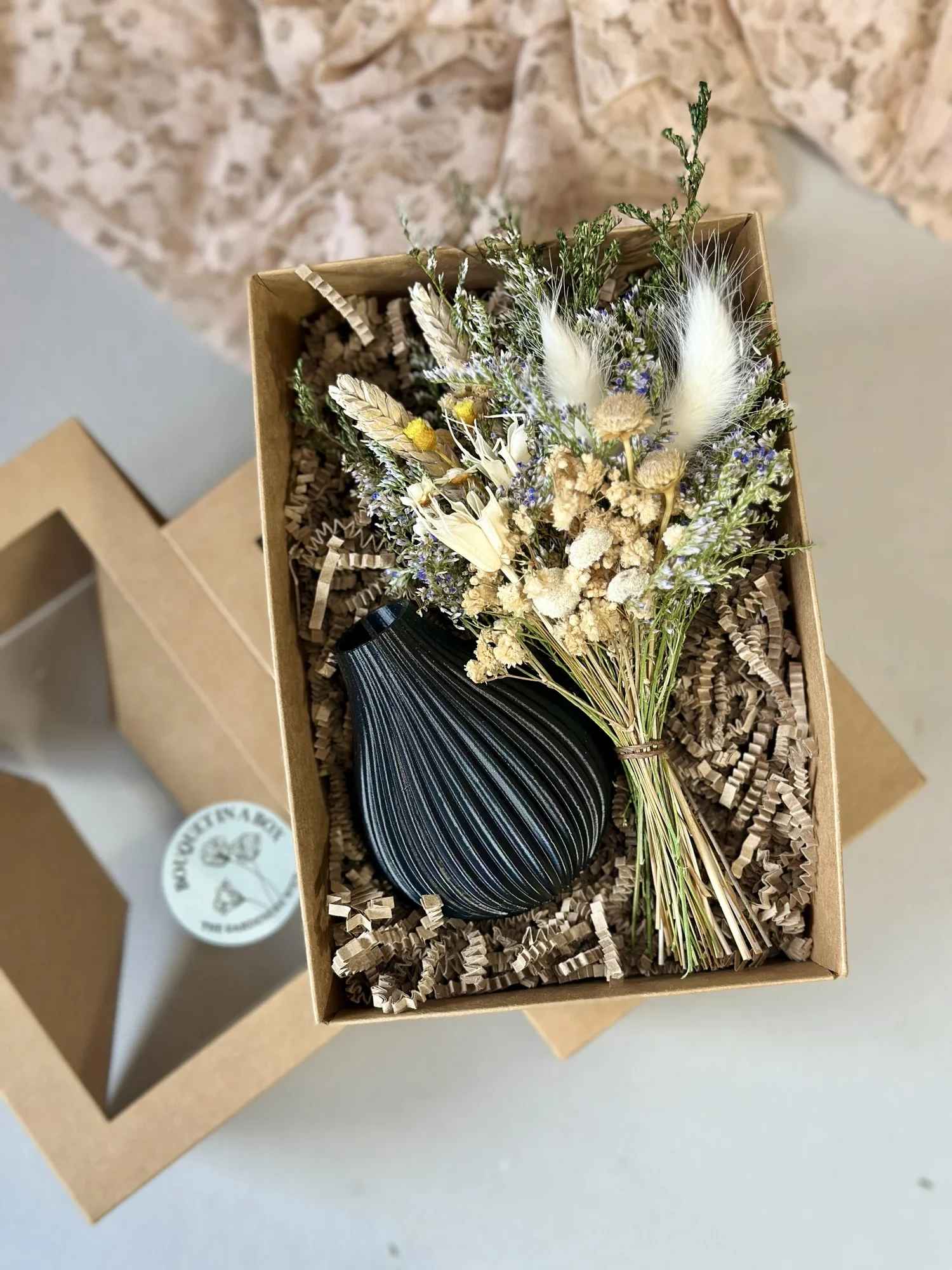 Bouquet in a Box with black vase - Give the gift of forever flowers! My Bouquet in a Box makes gifting simple, sustainable, and stunning. Each set includes a handcrafted dried floral bouquet paired with a 3D-printed vase made from recycled, eco-friendly plastic, created in collaboration with Boyds Custom Fabrication, a local maker specializing in modern, sustainable vases and planters!  Nestled securely in a stylish kraft gift box and cushioned with crinkle paper, this arrangement arrives ready to gift. A small flower care card is included to help your recipient enjoy their bouquet for years to come.  Perfect for holidays, birthdays, anniversaries, or just because, this thoughtfully made gift set combines art, sustainability, and craftsmanship — and makes a beautiful, lasting impression.  Details:  • Includes dried floral bouquet + 3D-printed eco-friendly vase  • Vase handmade by Boyds Custom Fabrication  • Vase colors: Cream, Olive, or Black  • Packaged in a sturdy kraft box with crinkle paper  • Includes dried flower care card  • Easy to wrap and gift-ready  • Made with real, dried, and preserved florals — no water needed