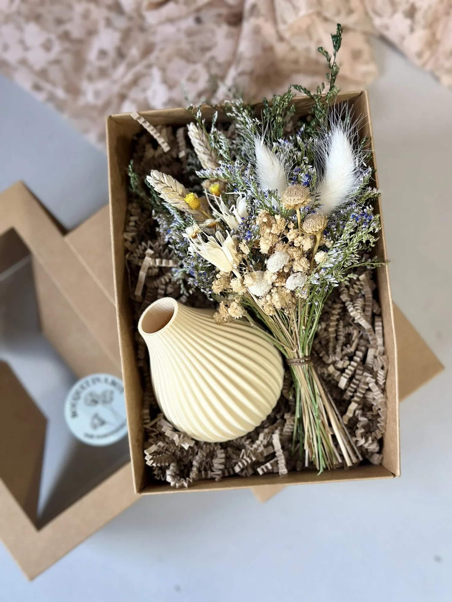 Bouquet in a Box with creme vase - Give the gift of forever flowers! My Bouquet in a Box makes gifting simple, sustainable, and stunning. Each set includes a handcrafted dried floral bouquet paired with a 3D-printed vase made from recycled, eco-friendly plastic, created in collaboration with Boyds Custom Fabrication, a local maker specializing in modern, sustainable vases and planters!  Nestled securely in a stylish kraft gift box and cushioned with crinkle paper, this arrangement arrives ready to gift. A small flower care card is included to help your recipient enjoy their bouquet for years to come.  Perfect for holidays, birthdays, anniversaries, or just because, this thoughtfully made gift set combines art, sustainability, and craftsmanship — and makes a beautiful, lasting impression.  Details:  • Includes dried floral bouquet + 3D-printed eco-friendly vase  • Vase handmade by Boyds Custom Fabrication  • Vase colors: Cream, Olive, or Black  • Packaged in a sturdy kraft box with crinkle paper  • Includes dried flower care card  • Easy to wrap and gift-ready  • Made with real, dried, and preserved florals — no water needed