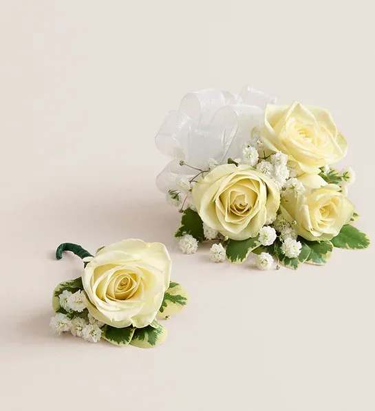 White Spray Rose Corsage &amp; Boutonniere (White) - NEW Make a special occasion even more memorable with our hand-designed corsage and boutonniere pairing. Each is made with carefully chosen white spray roses complemented with baby’s-breath and greenery. The corsage, which can be worn on the wrist or pinned to clothing, comes with ribbon in your choice of eight colors: black, gold, green, lavender, light pink, royal blue, silver, or white.
