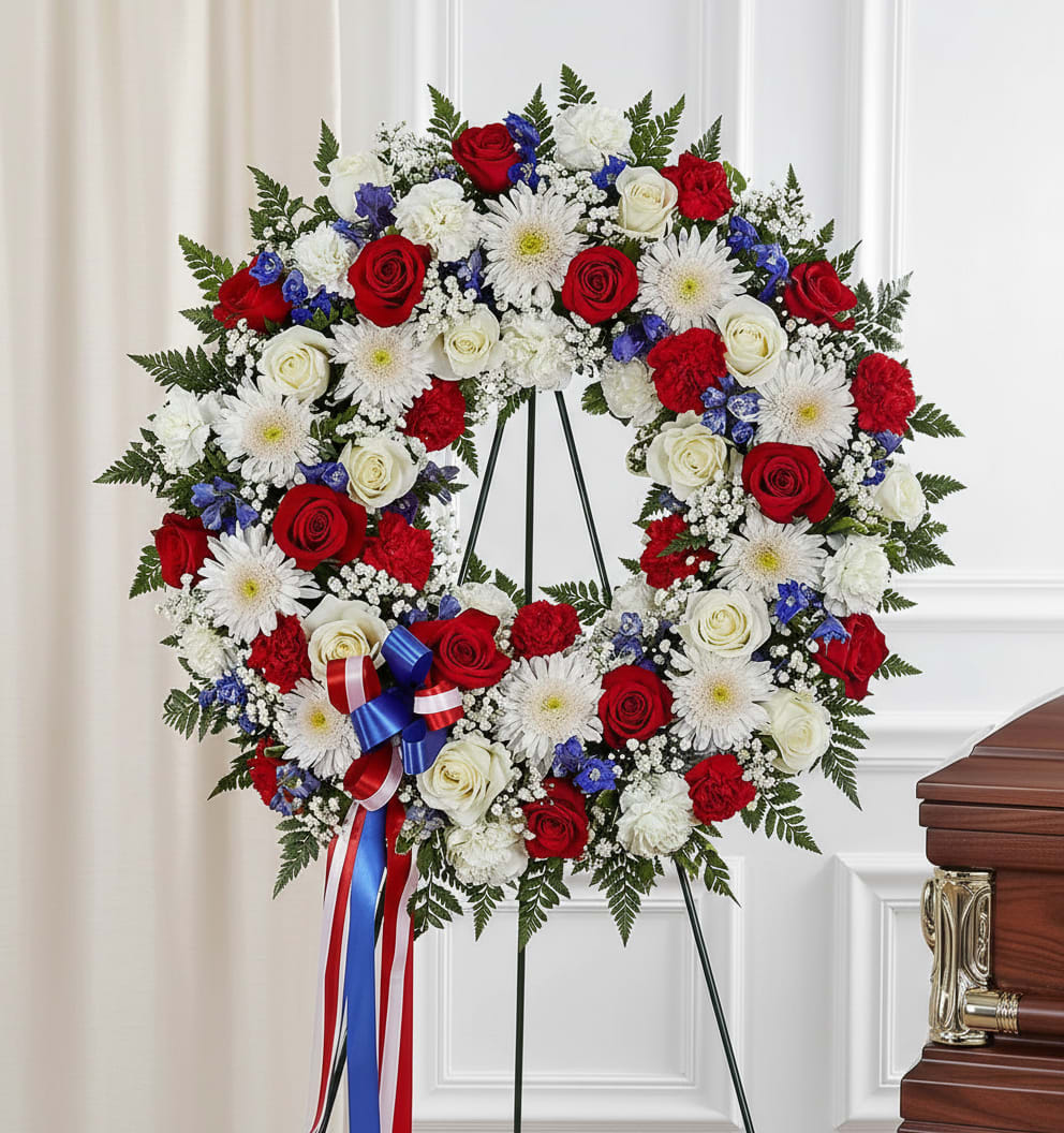 Heart-shaped funeral wreath of red and white roses with white daisies on an easel