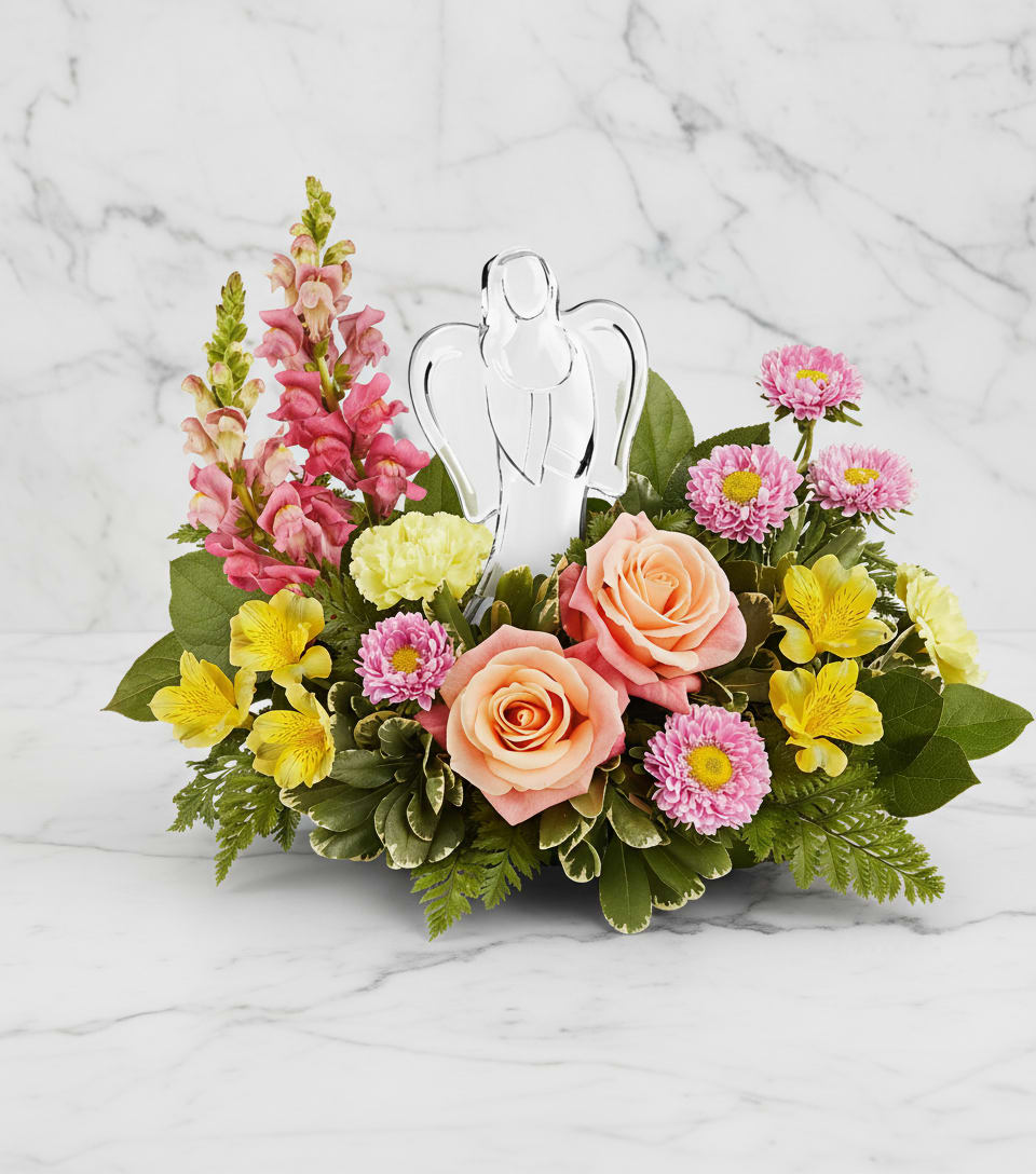 Angel's Embrace Bouquet - Radiating peace and comfort, our Angel's Embrace Bouquet surrounds a sparkling crystal angel keepsake with peach roses, pink blooms, and sunny yellow flowers-a graceful way to honor love's eternal light.