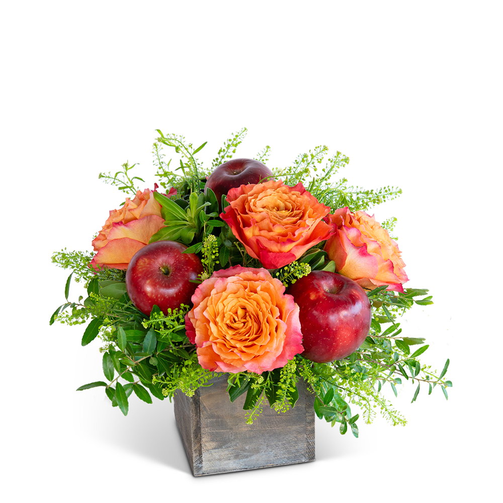 Rosy Orchard Bliss - Experience the enchanting beauty of our Rosy Orchard Bliss design, featuring stunning roses, premium foliage, and nestled apples for a touch of whimsical charm in a wooden cube container. This unique combination of blooms and fruit creates a lush and vibrant display that will brighten any space with its natural elegance. Consider upgrading for an even more lavish arrangement.