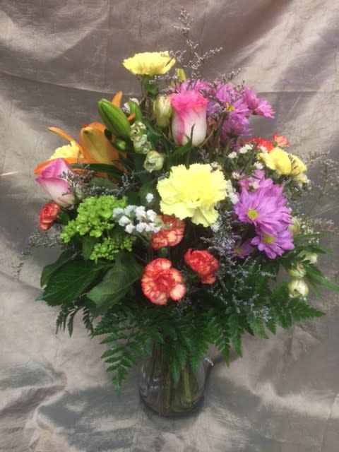 Mixed bouquet of colorful flowers in a glass vase