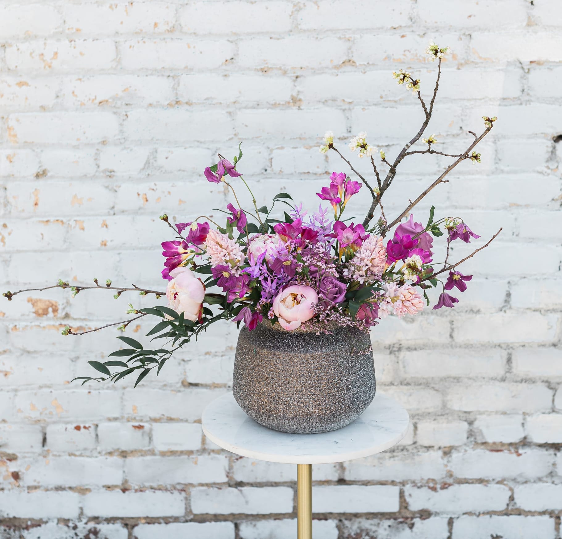 Pink and purple floral arrangement in a textured vase