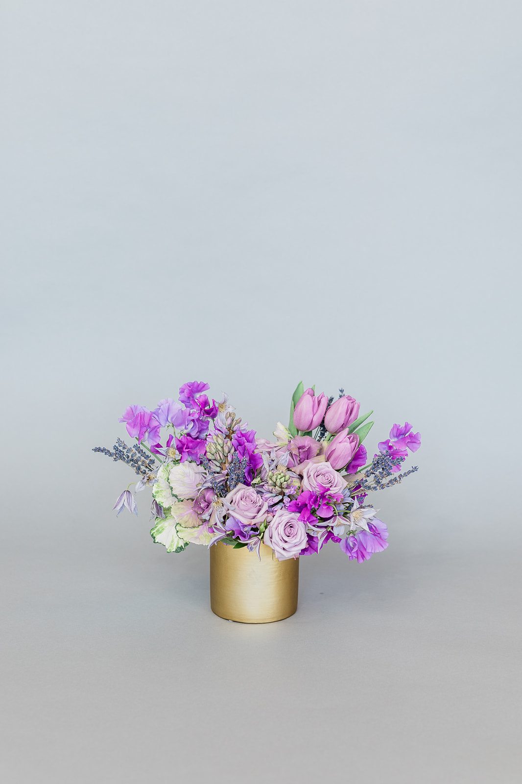 Lavender and pink bouquet in a gold cylinder vase