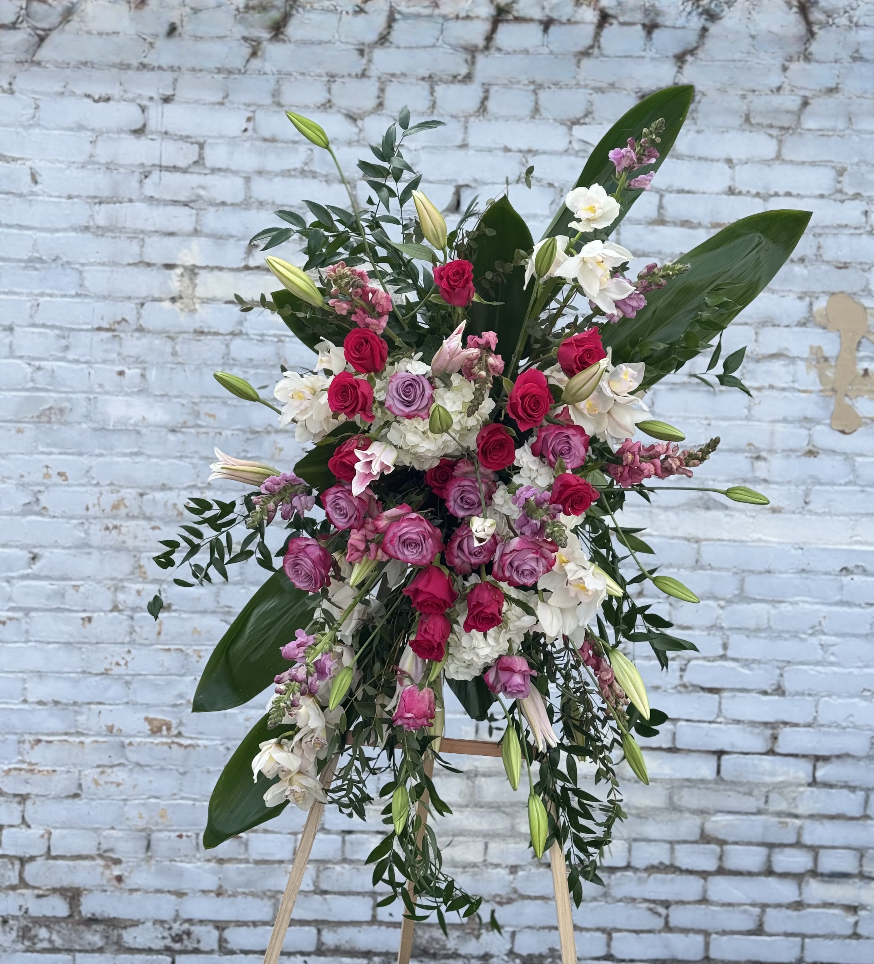 Large standing floral spray with pink and white roses on an easel