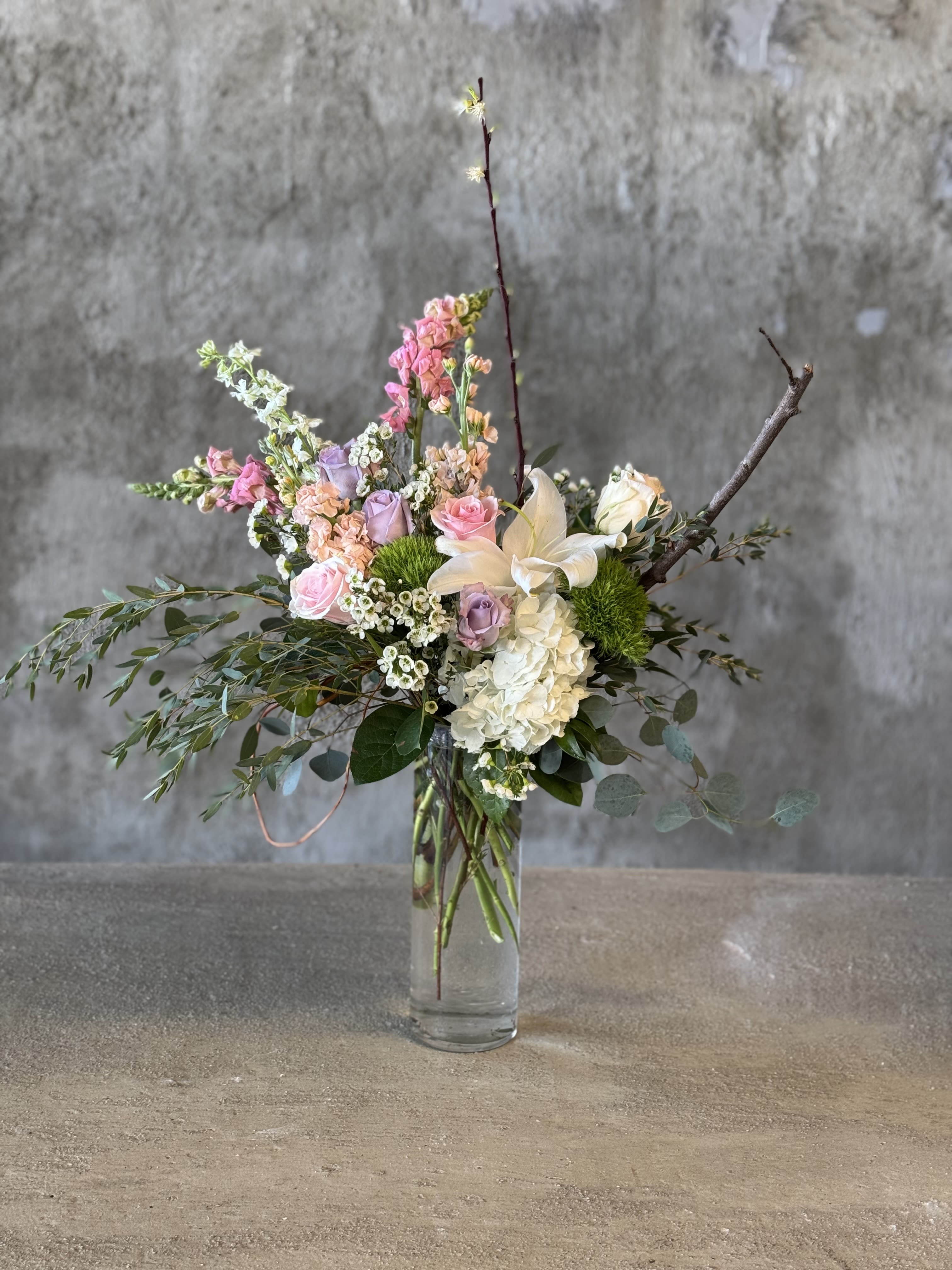 Mixed pastel flower arrangement in a clear glass vase