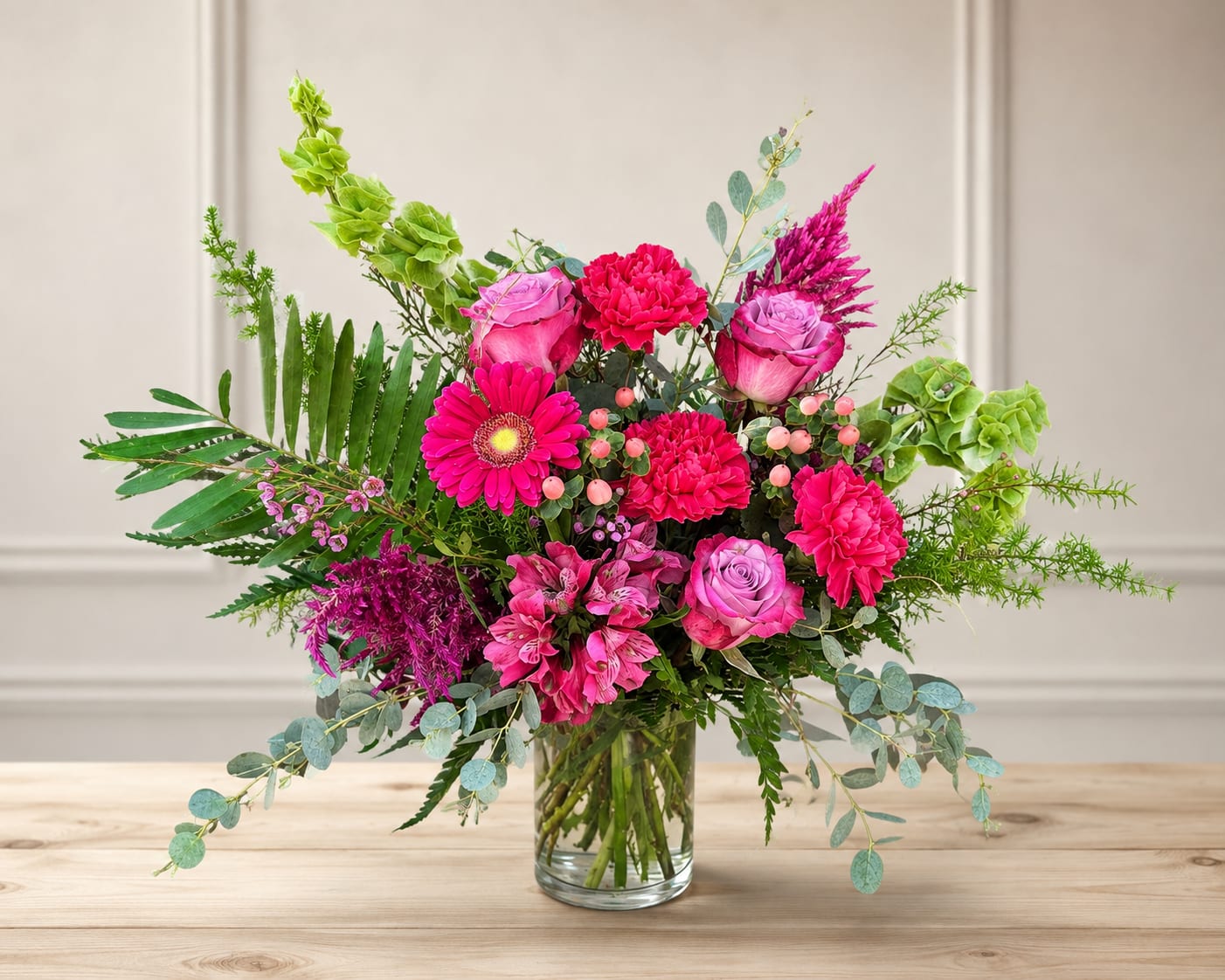 Bright pink mixed bouquet in a clear glass vase