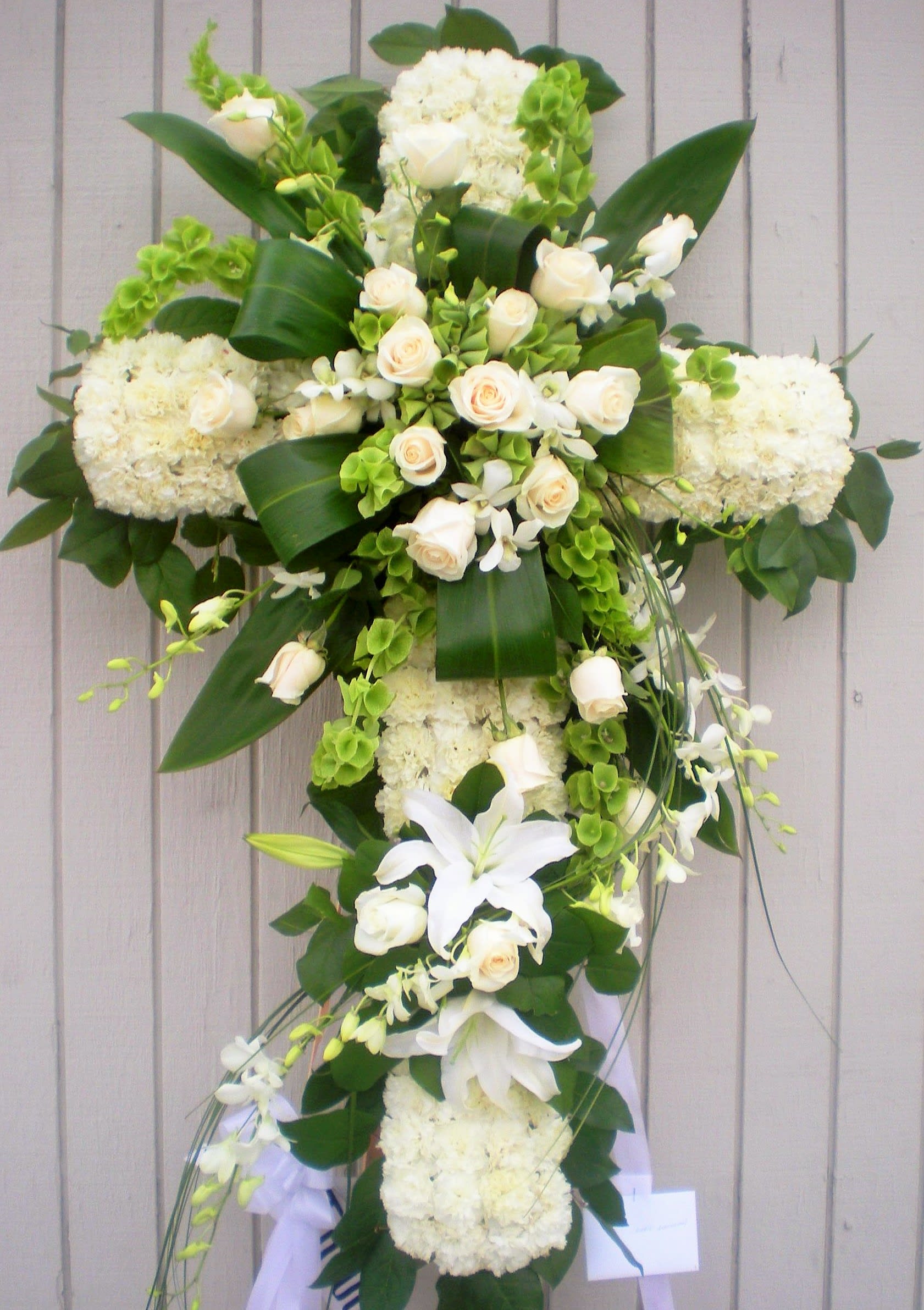 White floral cross arrangement with roses and lilies