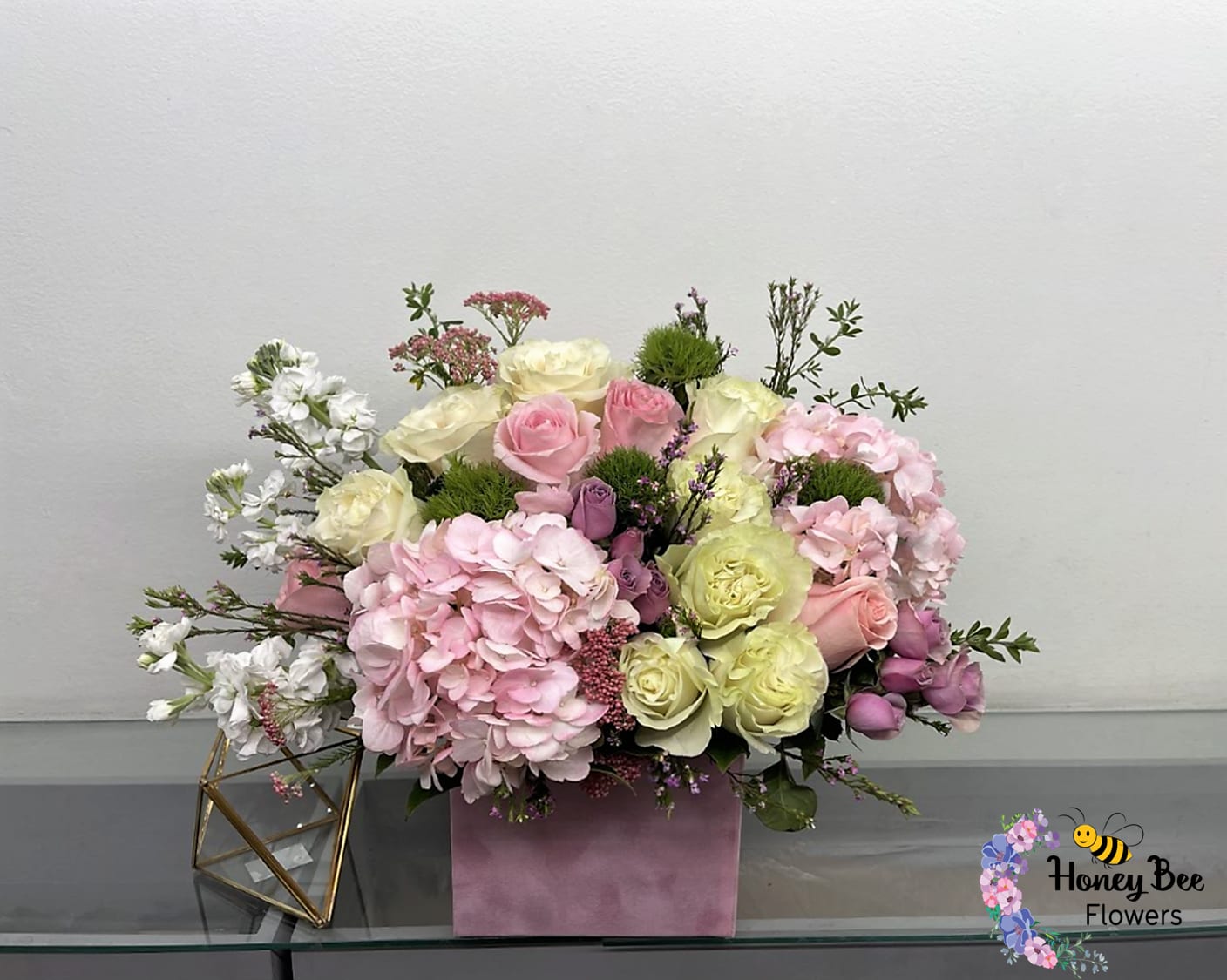Pink and cream rose arrangement with hydrangeas in a pink box