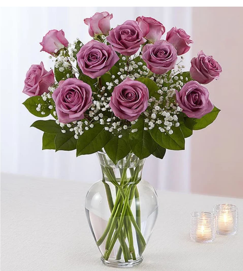 Pink roses arranged in a clear glass vase with baby's breath