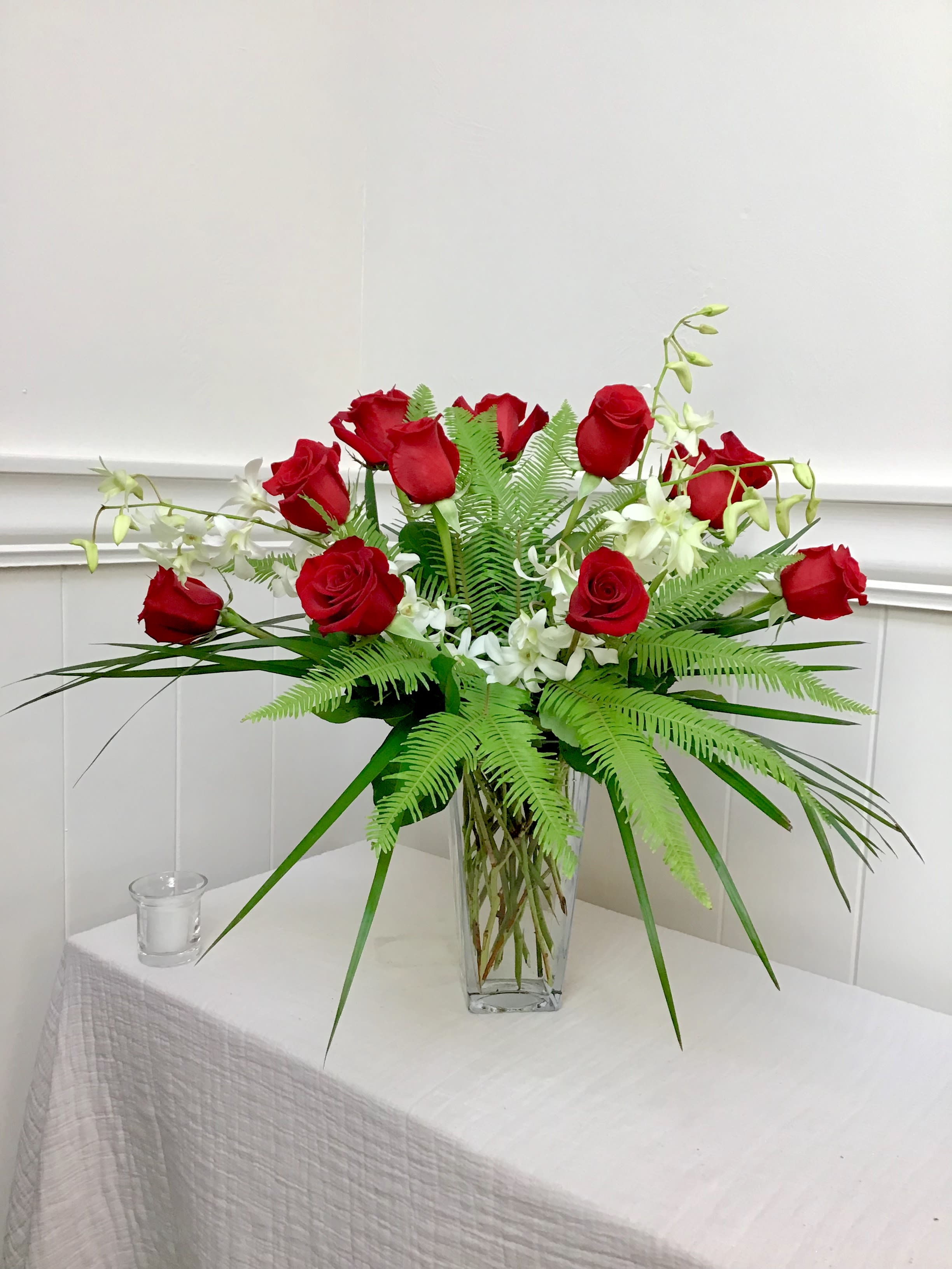 Red roses and white orchids in a clear glass vase