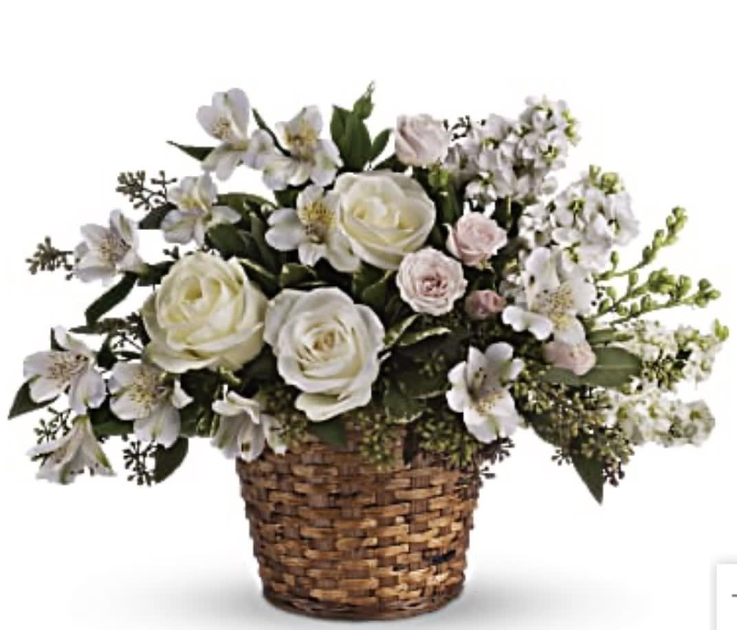 White roses and pale flowers in a woven basket