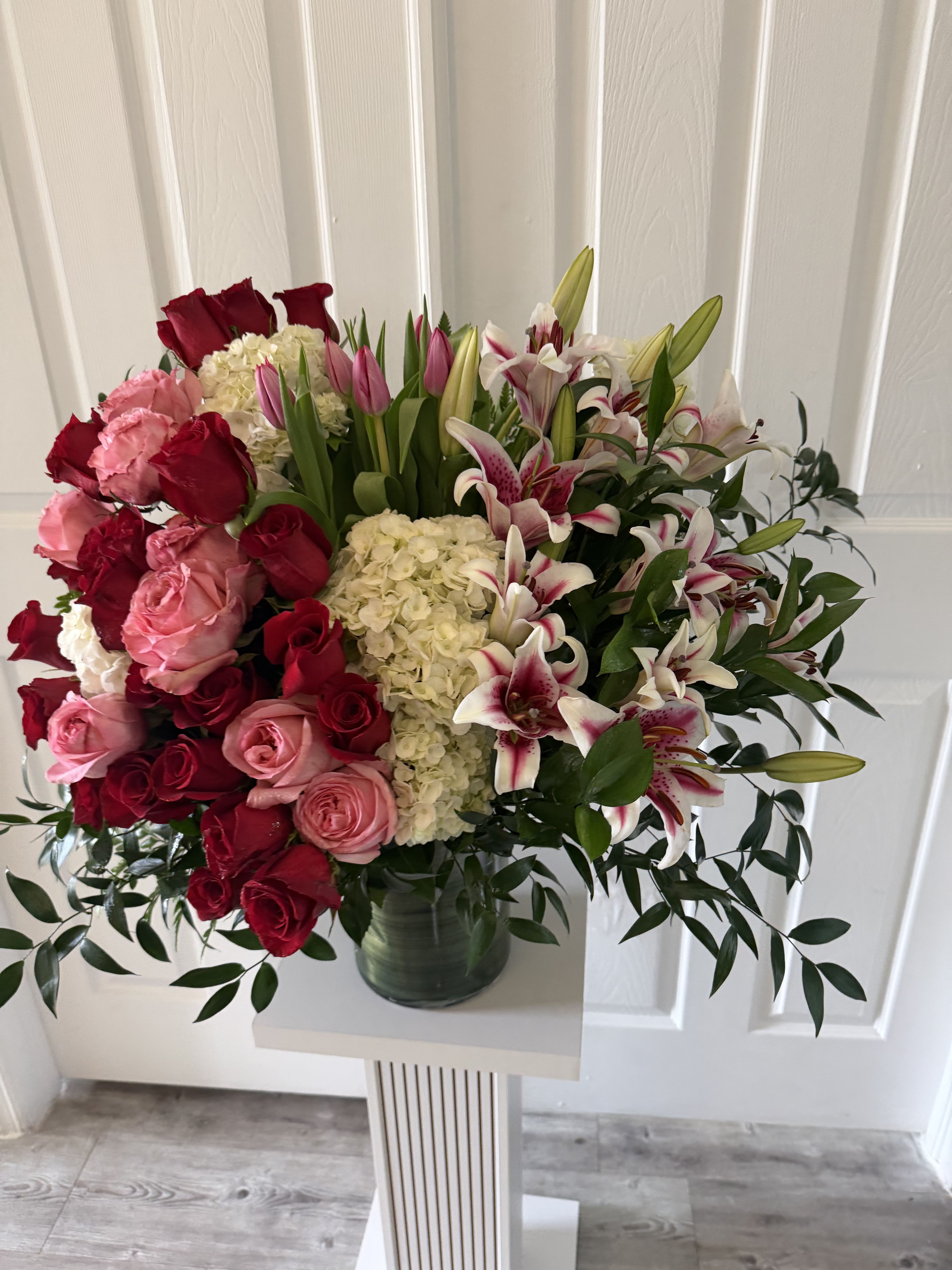Blooming Love - Blooming Love is a stunning floral arrangement designed to express the deepest emotions. This exquisite composition features elegant stargazer lilies, passionate red and pink roses, complemented by lush hydrangeas and delicate tulips.  A true symphony of love, each bloom comes together in perfect harmony to create a luxurious and unforgettable gift. Ideal for romantic occasions, anniversaries, or simply to say “I love you” in the most beautiful way.   A masterpiece of elegance, romance, and timeless beauty.