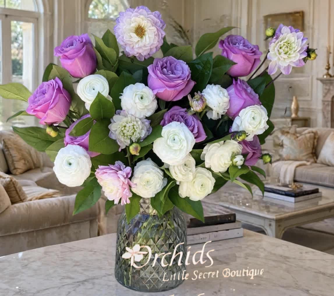 Purple and white flower arrangement in a glass vase