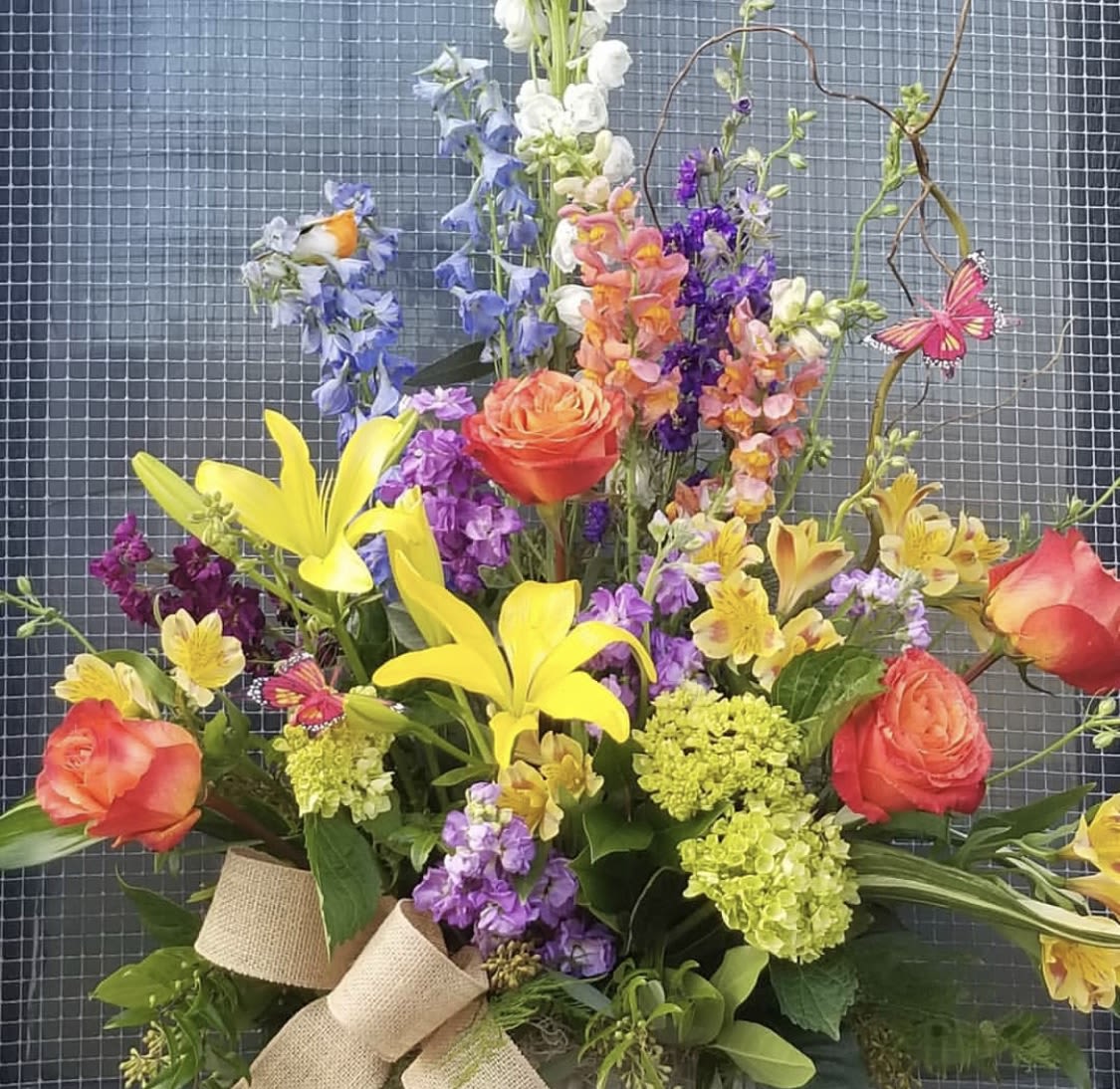 Colorful bouquet with yellow lilies, orange roses, and purple flowers
