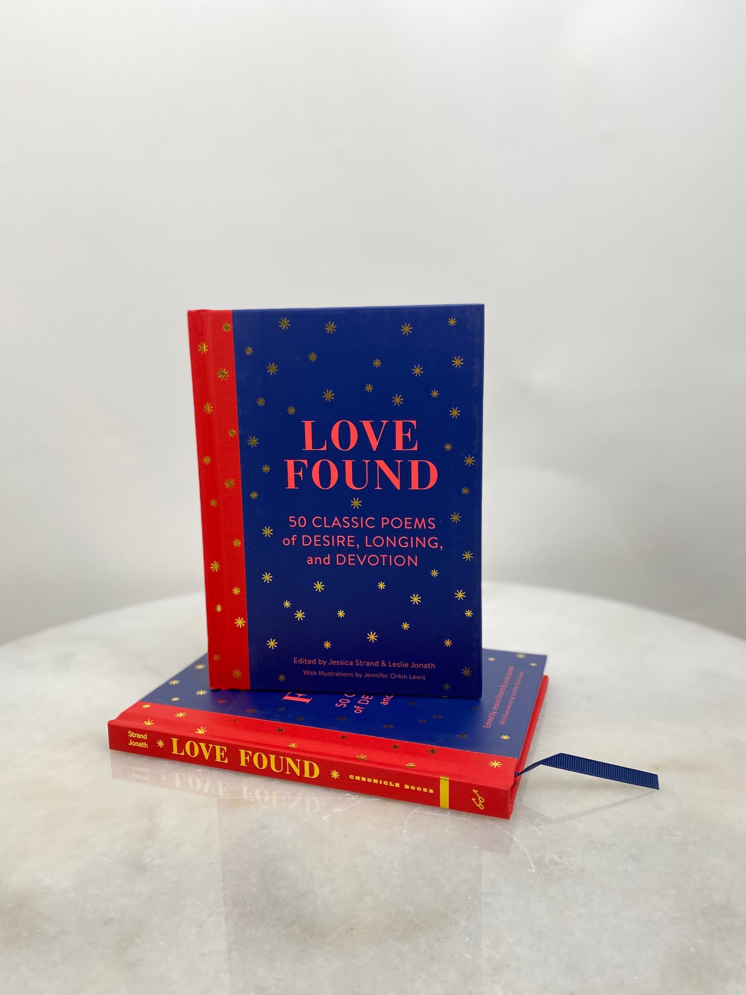 Two stacked books with blue and red covers titled Love Found