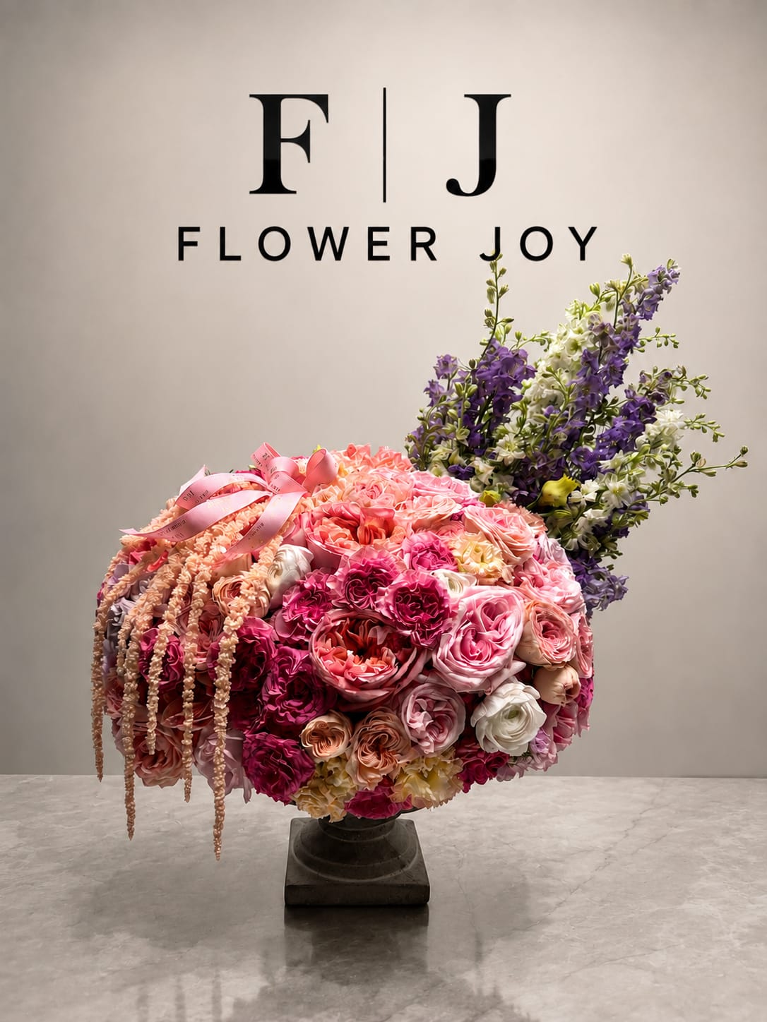 Large pink and purple floral arrangement in a pedestal vase