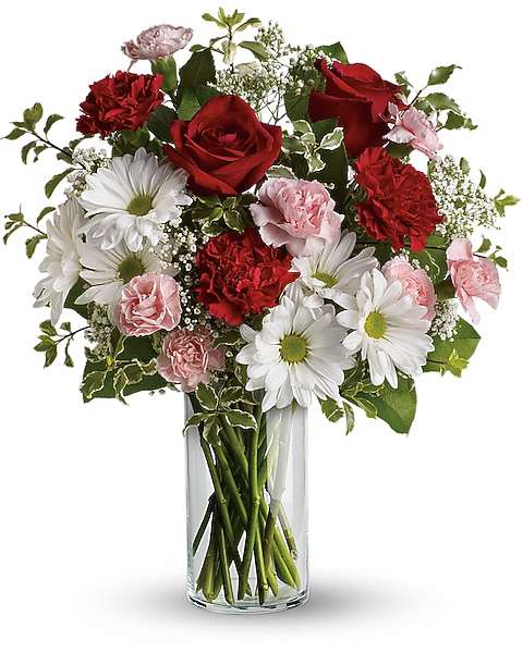 Bouquet of red roses, white daisies, and pink carnations in a clear glass vase