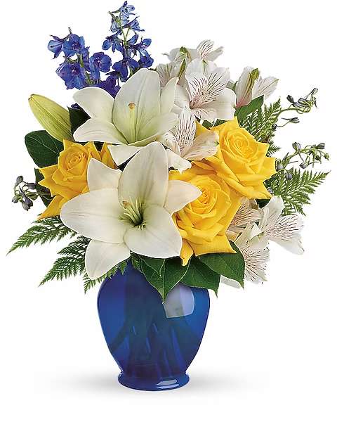 Bouquet of white lilies, yellow roses, and blue flowers in a blue vase