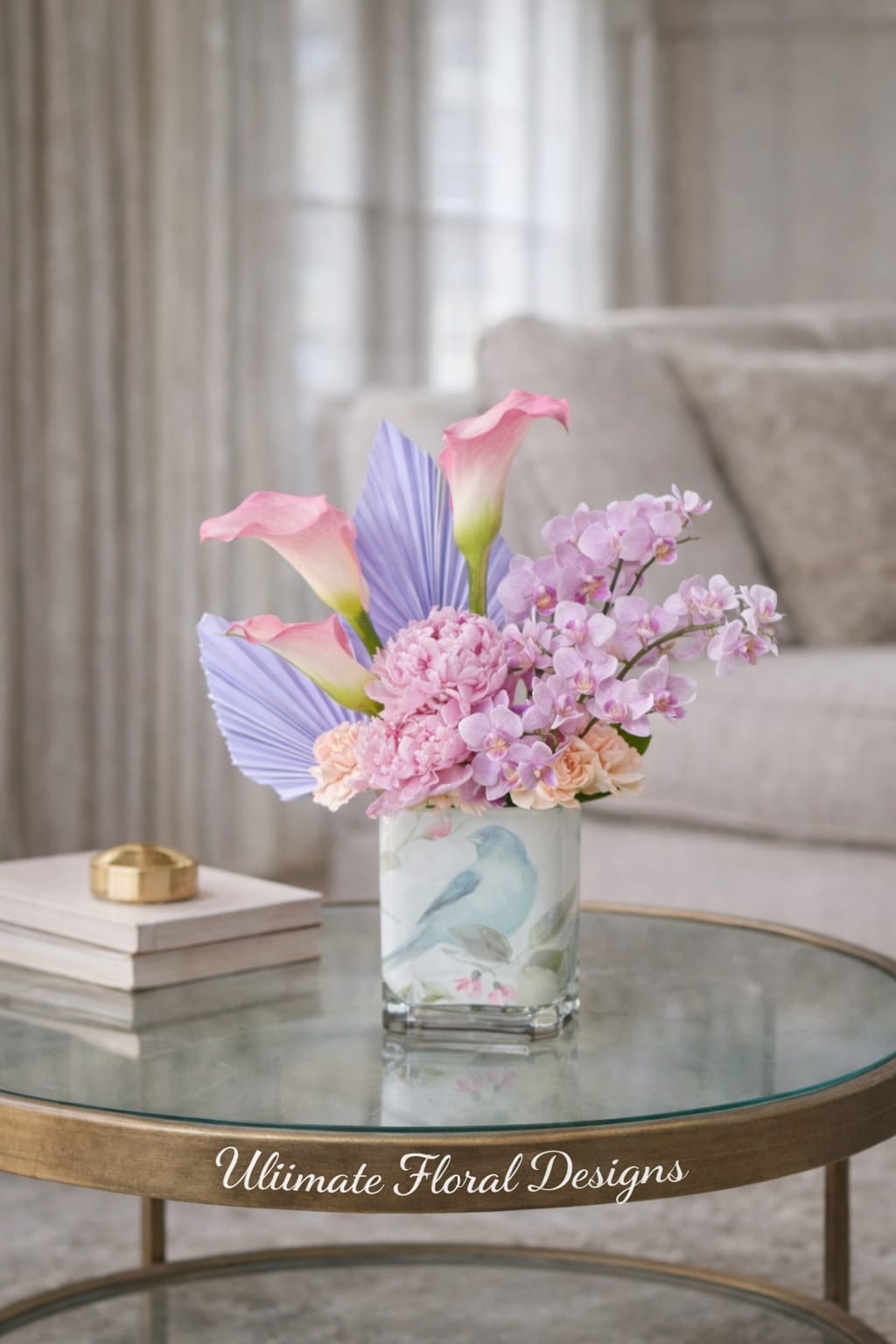 Pink calla lilies and lavender orchids in a glass vase