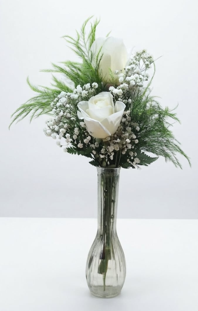 Two White Roses in Bud Vase - Two white roses arranged in a clear bud vase create a quietly elegant sympathy arrangement or small wedding accent. The clean white-and-green palette and upright silhouette make this flower arrangement a tasteful choice for a memorial, a ceremony, or any moment when you want to convey calm, respect, and gentle care to the person you're thinking of.  