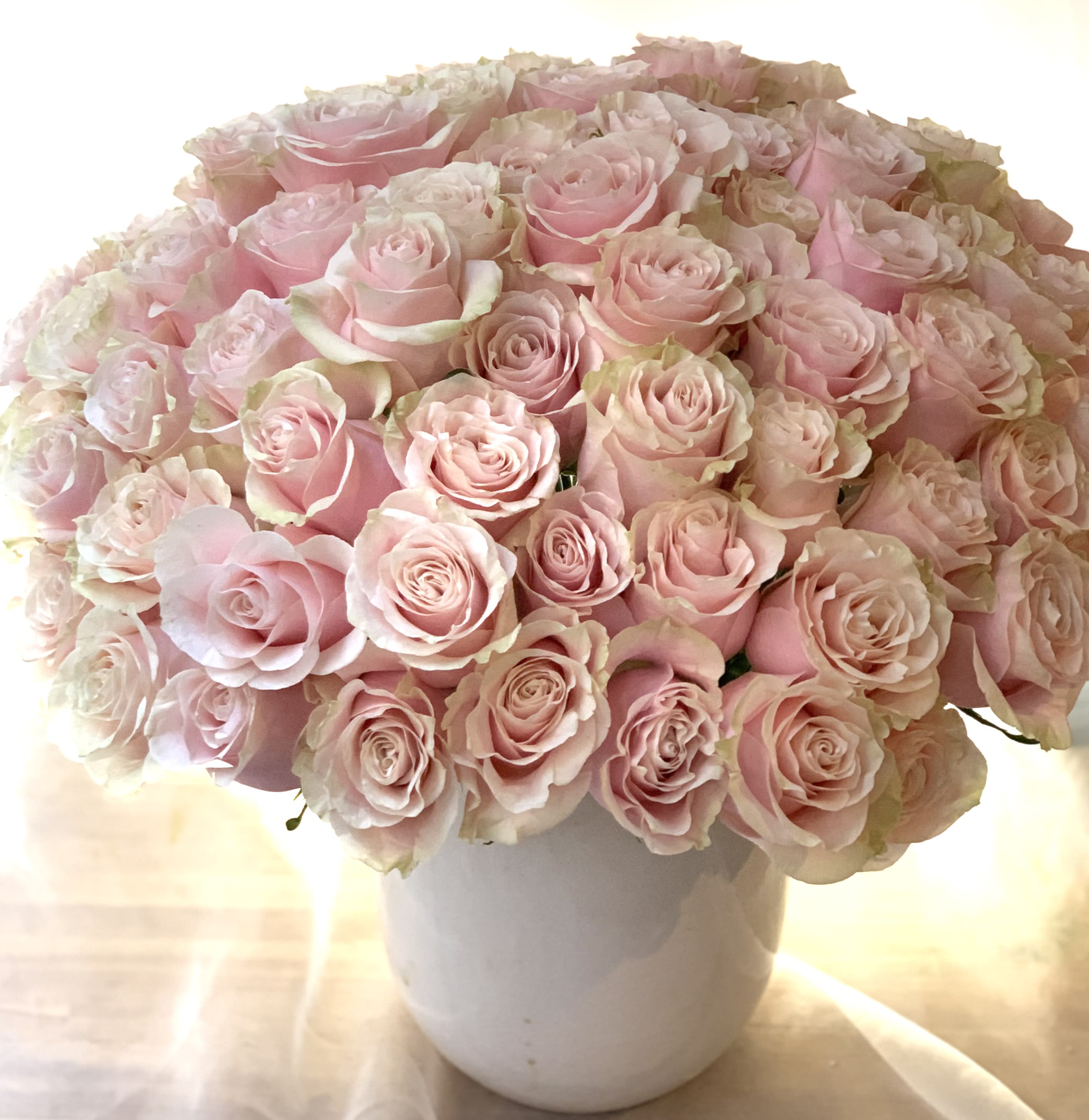 Bouquet of pale pink roses in a white vase