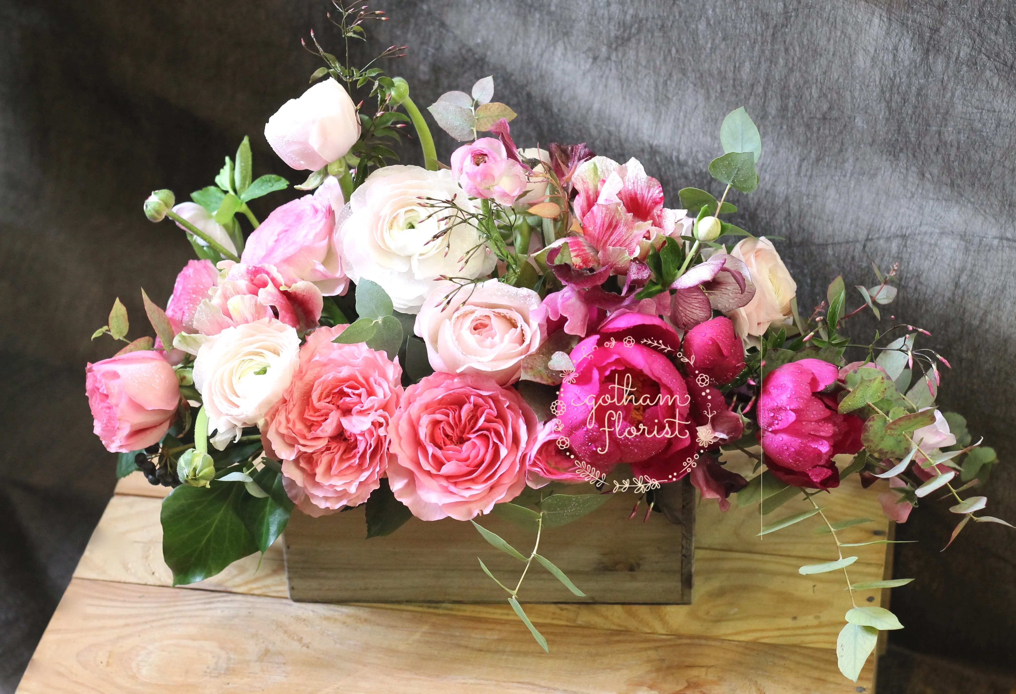 Pink and white roses arranged in a wooden box