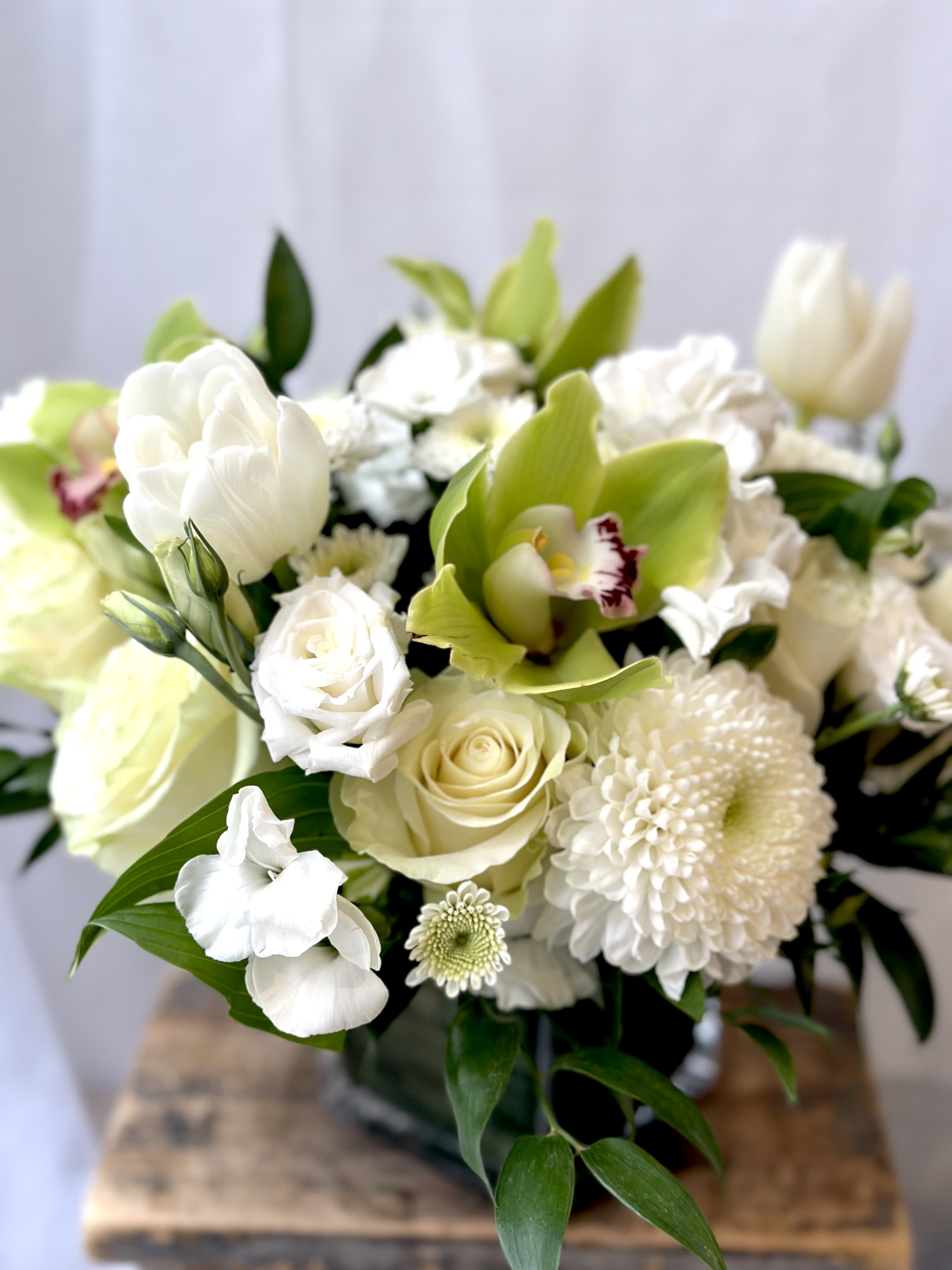 White and pale green bouquet with roses, orchids, and mums
