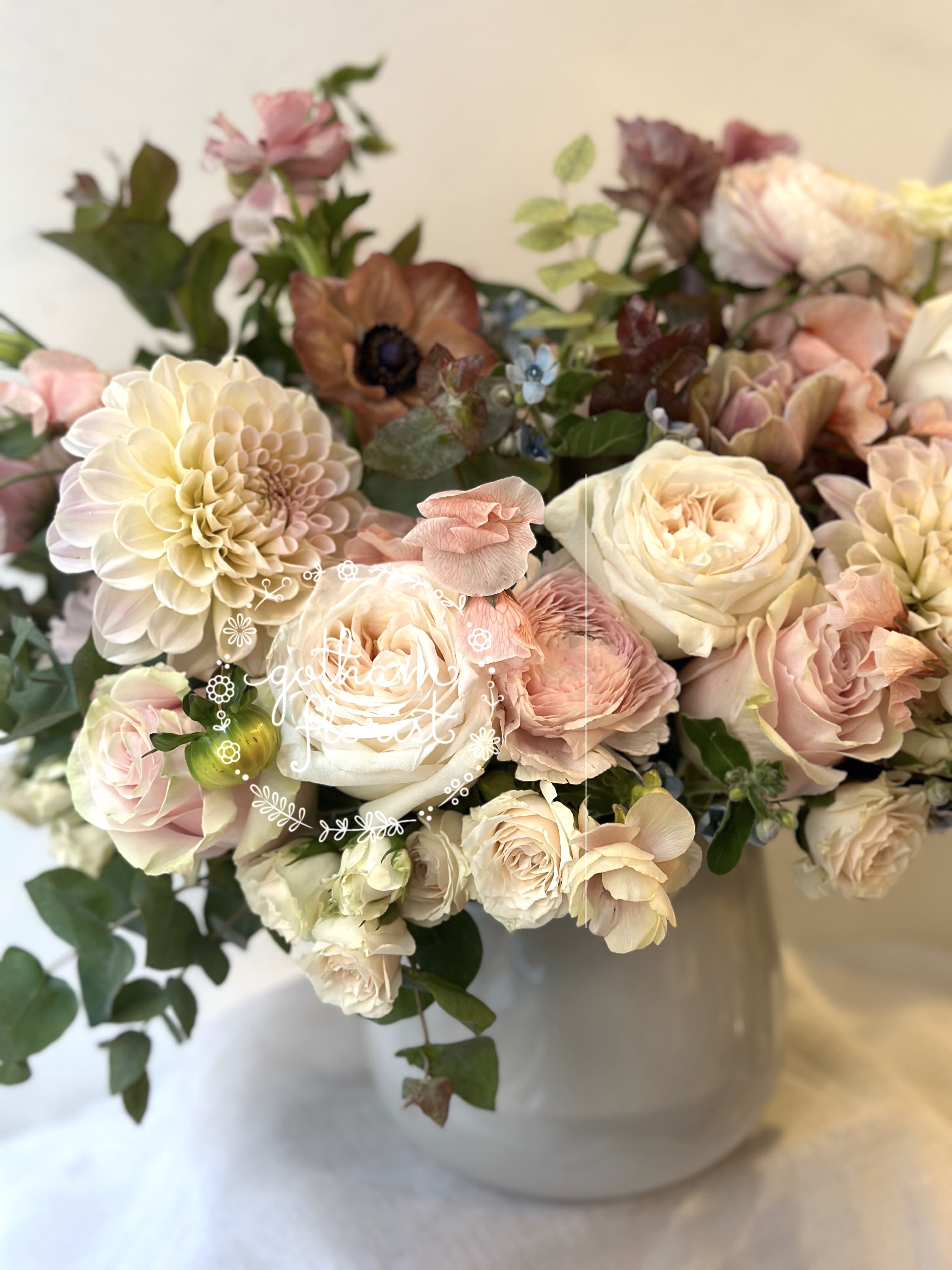 Bouquet of blush and cream flowers in a white vase