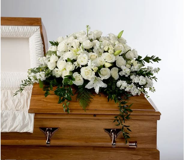 White floral spray on a wooden casket