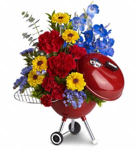 Red grill-shaped planter filled with colorful flowers