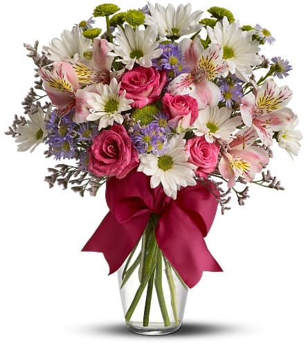 Bouquet of pink roses, white daisies, and alstroemeria in a glass vase