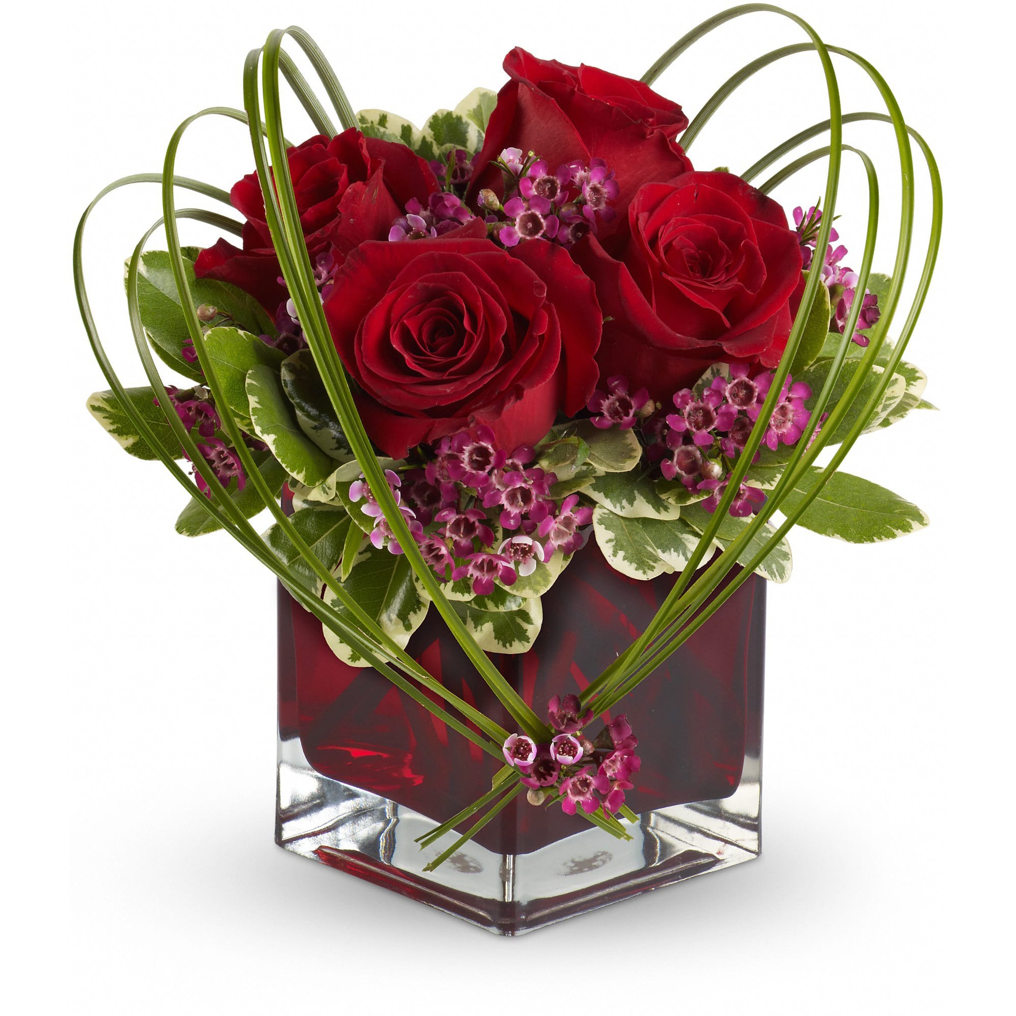 Teleflora's Sweet Thoughts Bouquet with Red Roses - If you'd like someone to think sweet thoughts about you, send them this delightful bouquet! A graceful heart of bear grass is tied with purple waxflower, and appears to float above red roses nestled in a ruby-red glass vase. How sweet it is! 