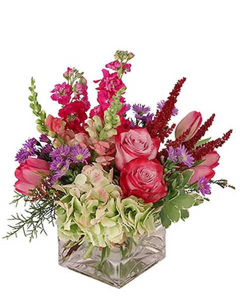 Pink and purple mixed bouquet in a square glass vase