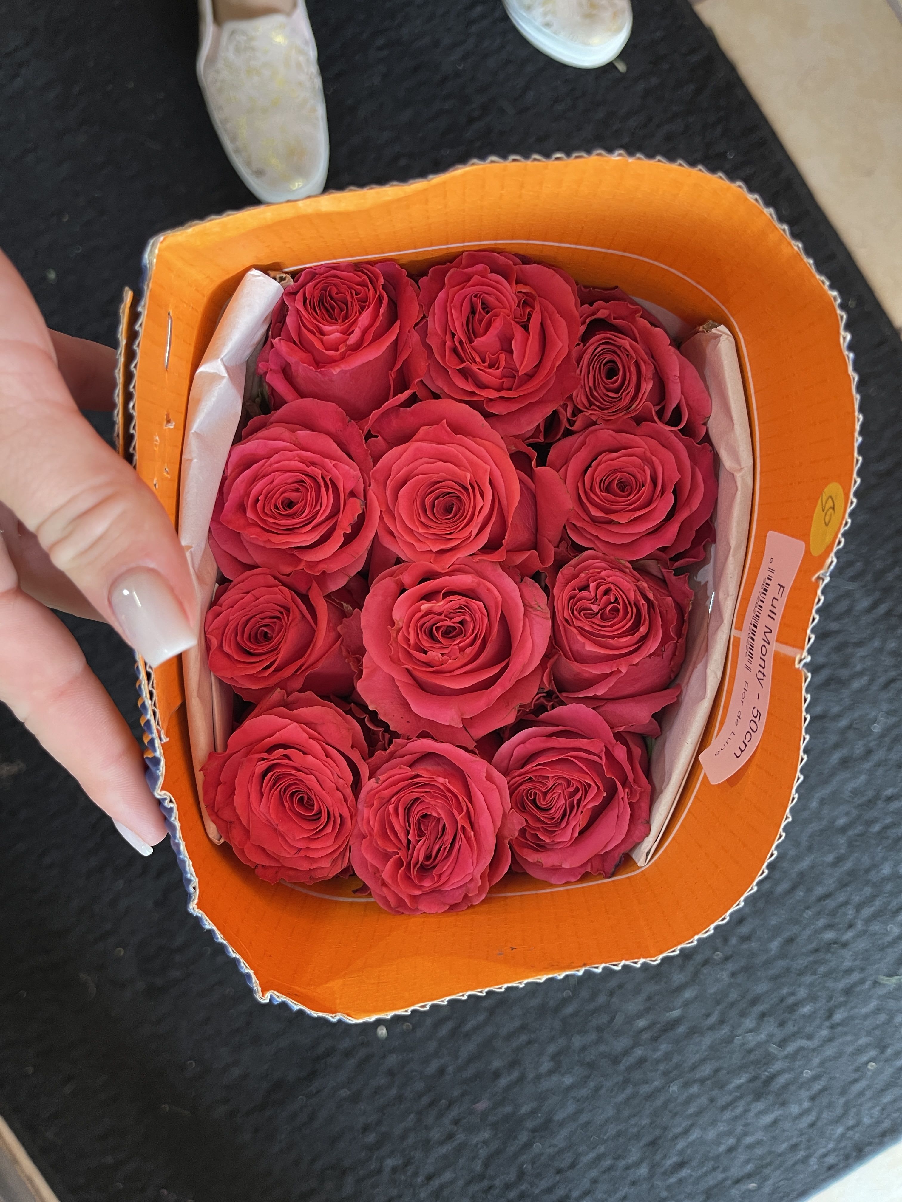 A small box of bright pink roses arranged tightly together