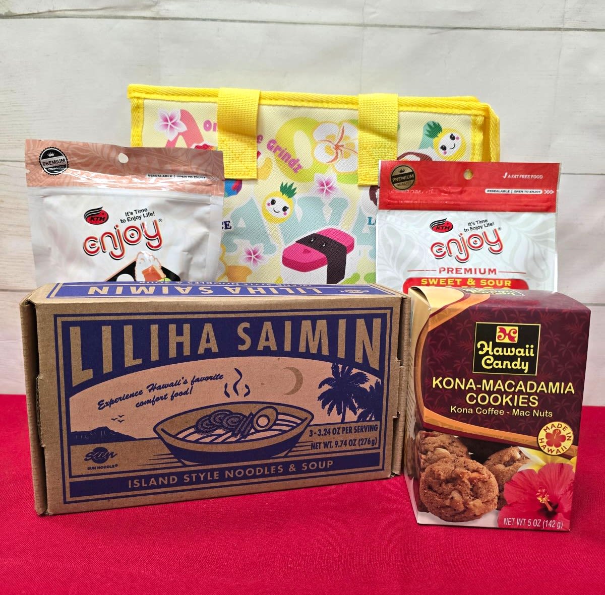 Hawaiian snack gift set with noodle box, cookies, snack bags, and a yellow printed tote.